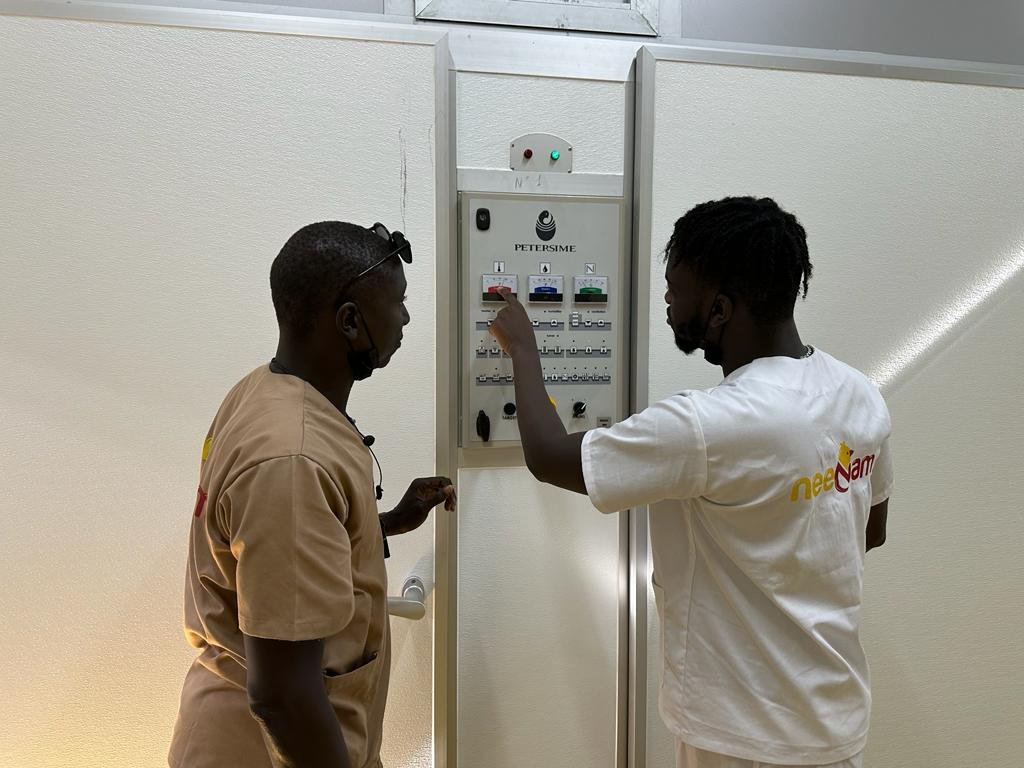 Les agents du couvoir Neenam travaille sur une machine de marque Petersime. Il s'agit d'un incubateur ou d'un éclosoir petersime