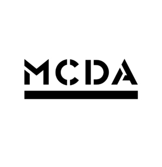 Black background with a white rectangular logo containing the text 'MCDA' in stylized letters.