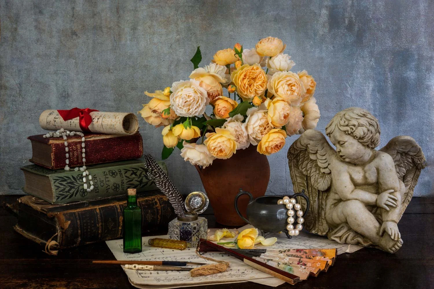 Still life of roses, cherub, books , fan and music, by Wendy Akers 