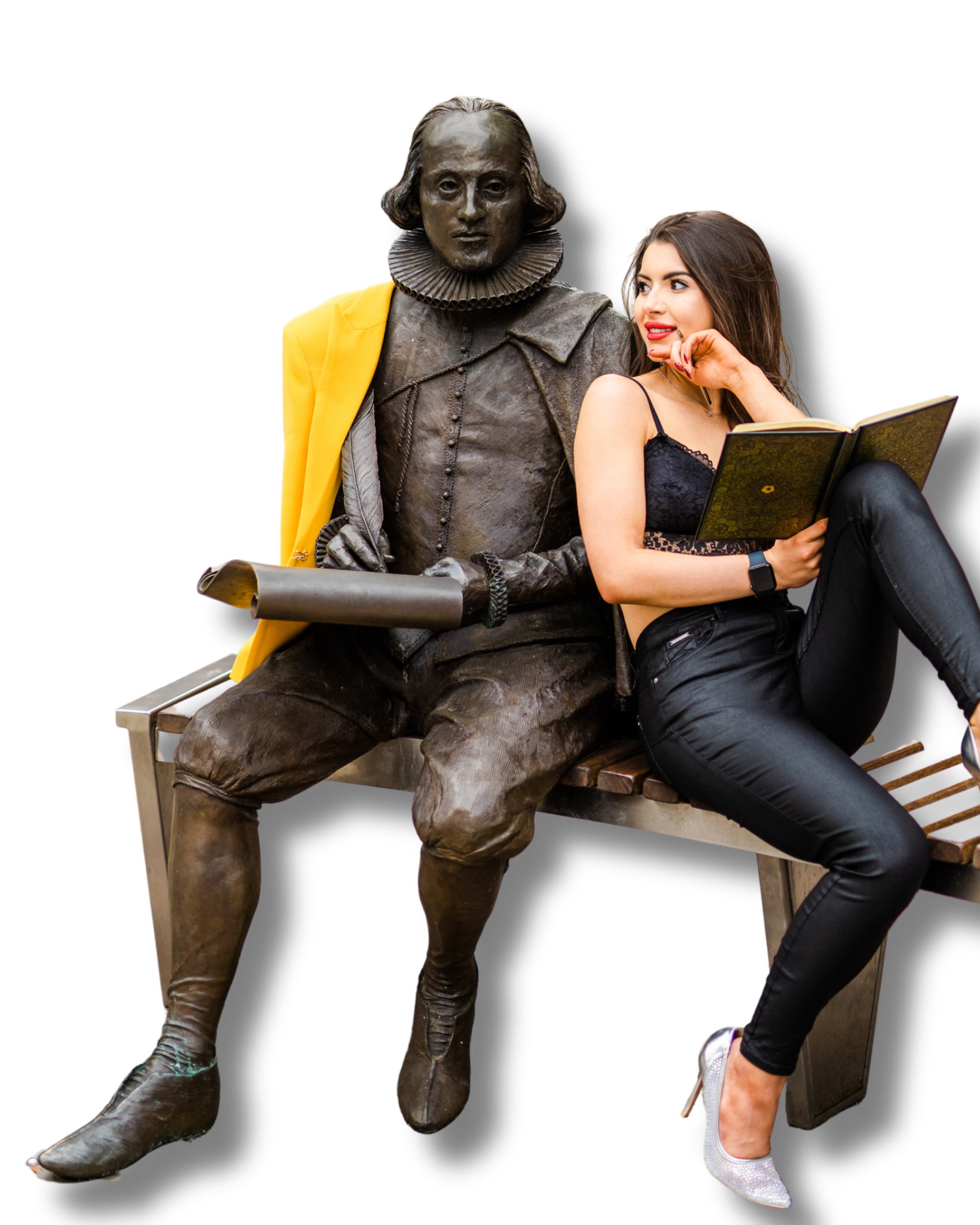 A woman sitting next to a bronze statue of William Shakespeare. The woman is wearing black pants, a black lace top, and white high-heeled shoes, and is holding an open book. The statue depicts William Shakespeare in period clothing with a ruffled collar, sitting on a bench, with one leg crossed over the other.