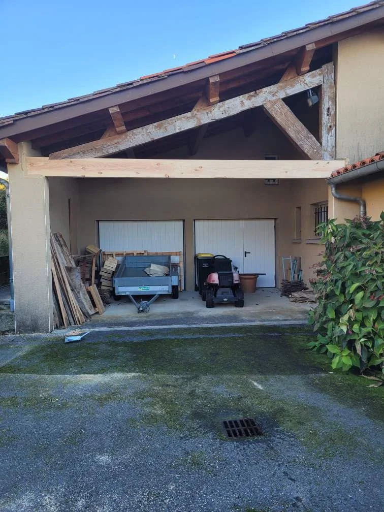 Garage avec des outils de jardinage, une remorque à bois, une petite voiture électrique pour enfants, et des plantes