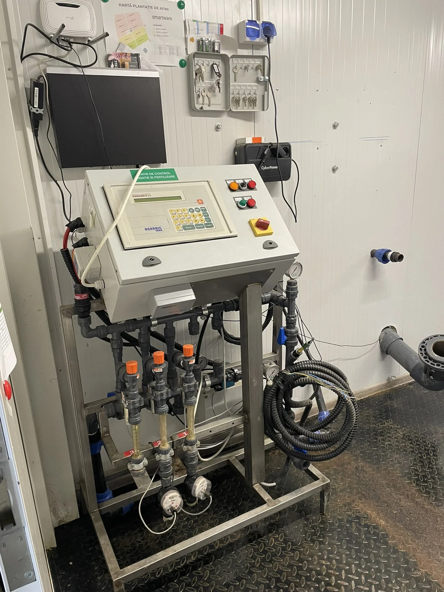 Industrial water treatment or filtration system with control panel, gauges, pipes, and various valves in a clean, industrial facility.