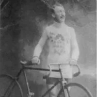 Blurry black-and-white photo of a person standing with a bicycle outdoors.