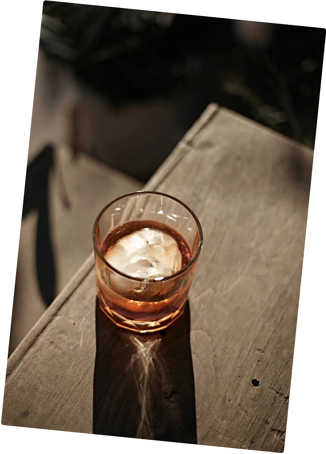 Verre de boisson avec glace sur une table en bois, en prise de vue en plongée.