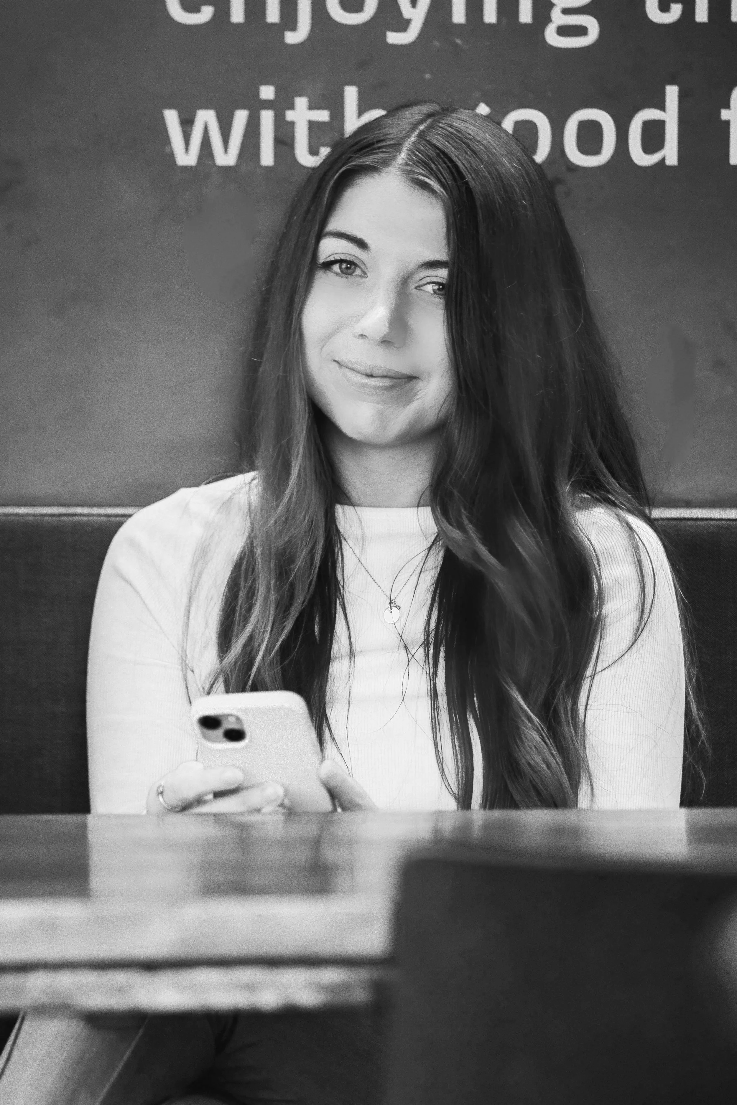 Woman smiles as she hold a phone