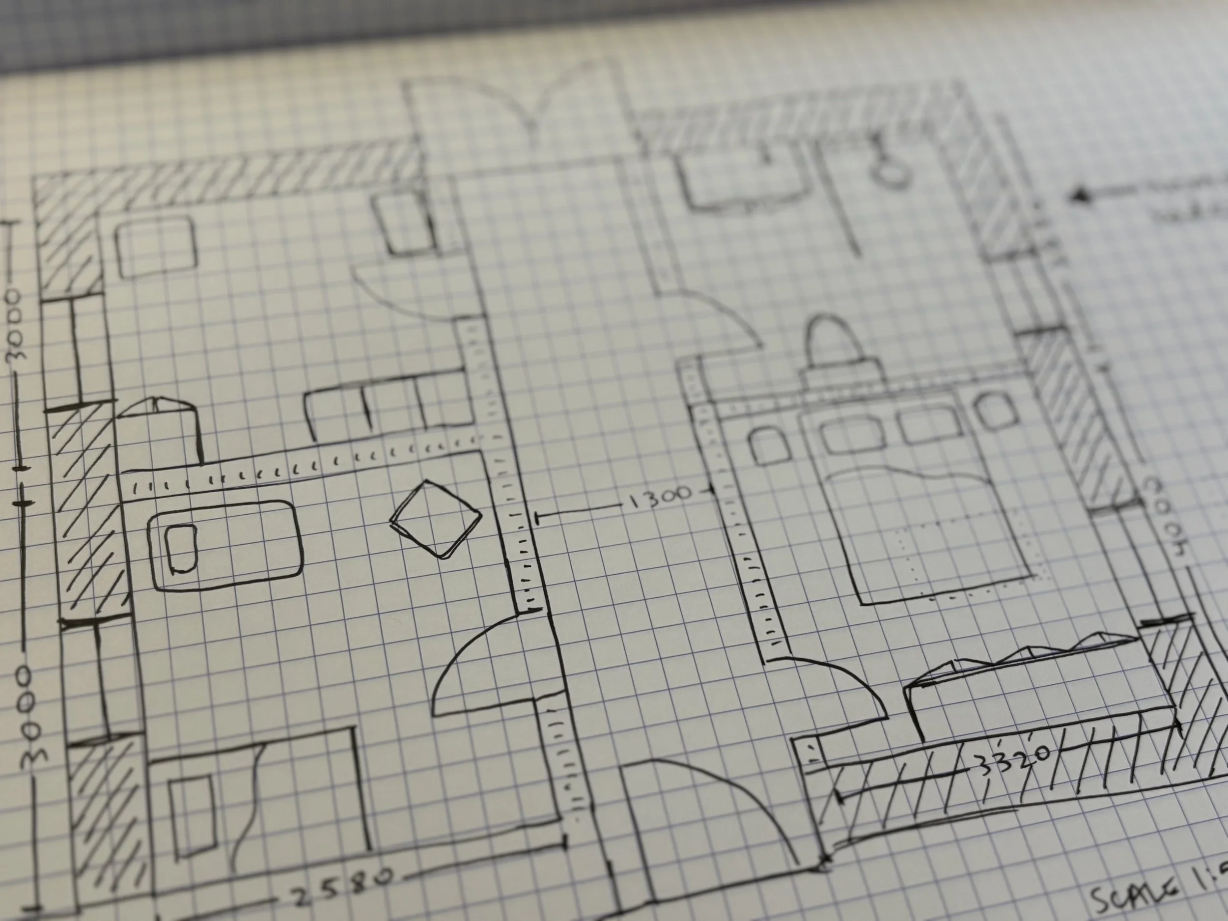 Architectural floor plan sketched on graph paper showing rooms, doors, and measurements.