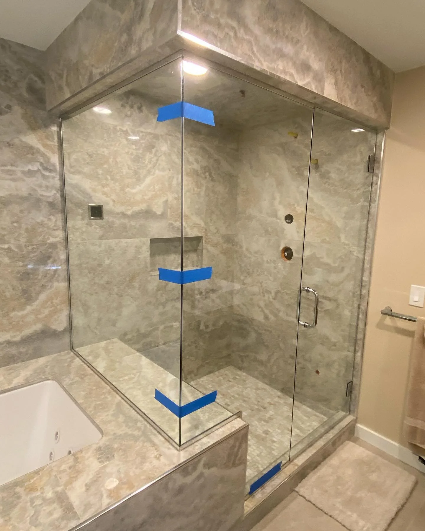 Frameless glass steam shower enclosure running to a stone-look tile soffit beside a jetted tub in a Kennebunkport, Maine bathroom