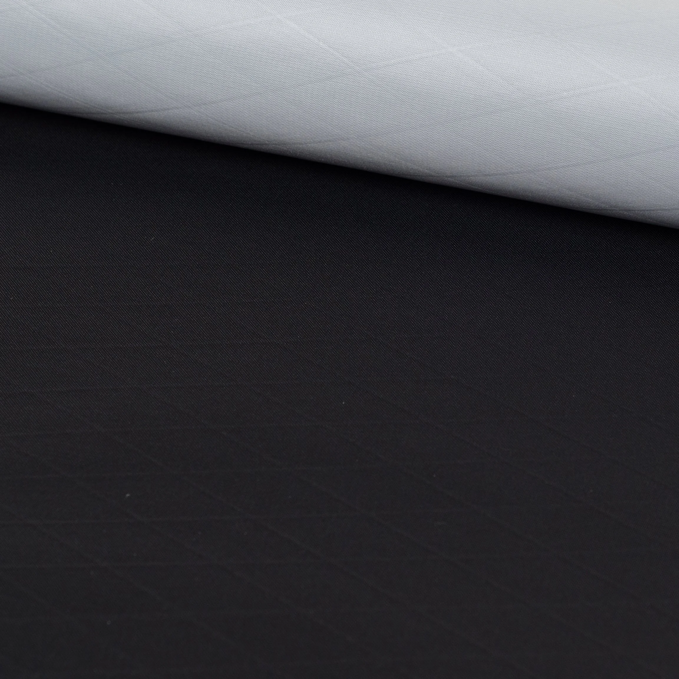 Close-up of a rolled up piece of black textured fabric.