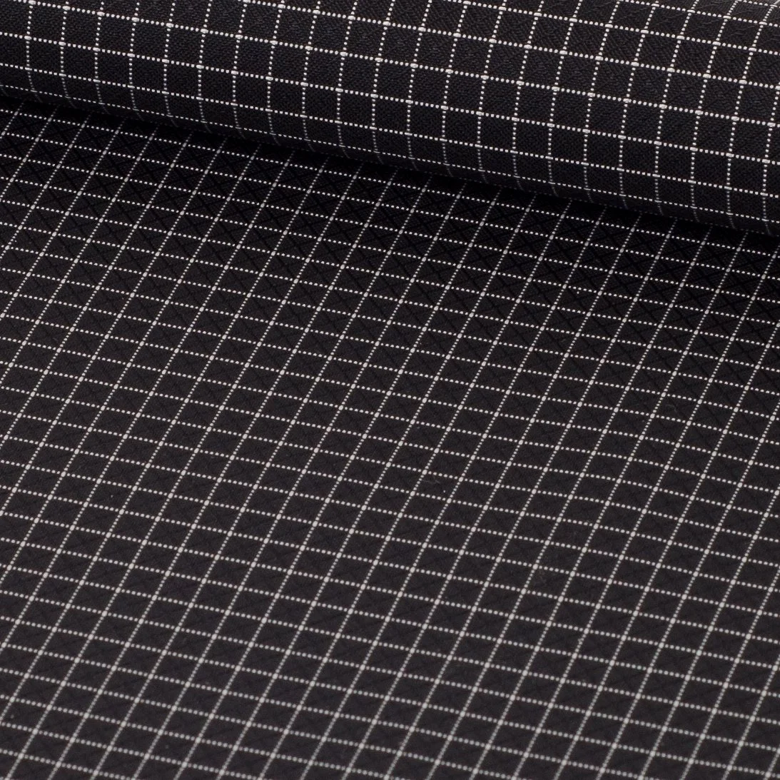 Close-up of black fabric with white grid pattern.