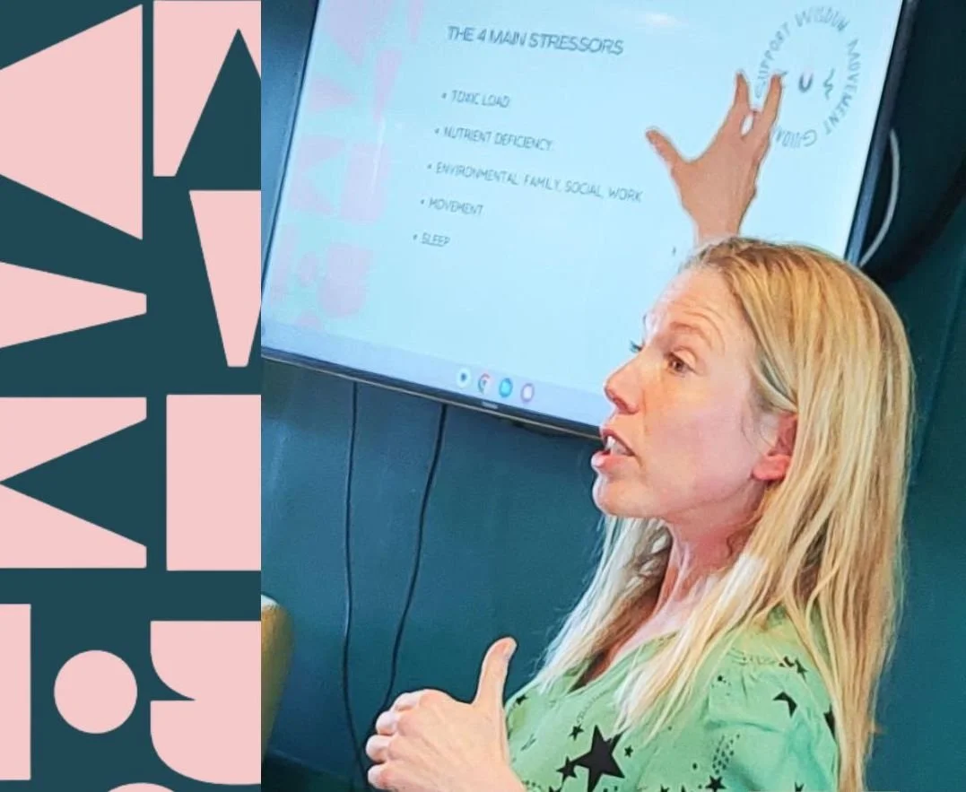 Abi Adams is gesturing towards a screen behind her with text on it. She is looking away from the camera and is speaking.