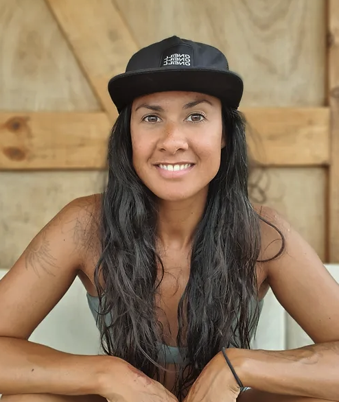 Lisa Sha, a swimmer, is sitting down, looking into the camera and smiling.