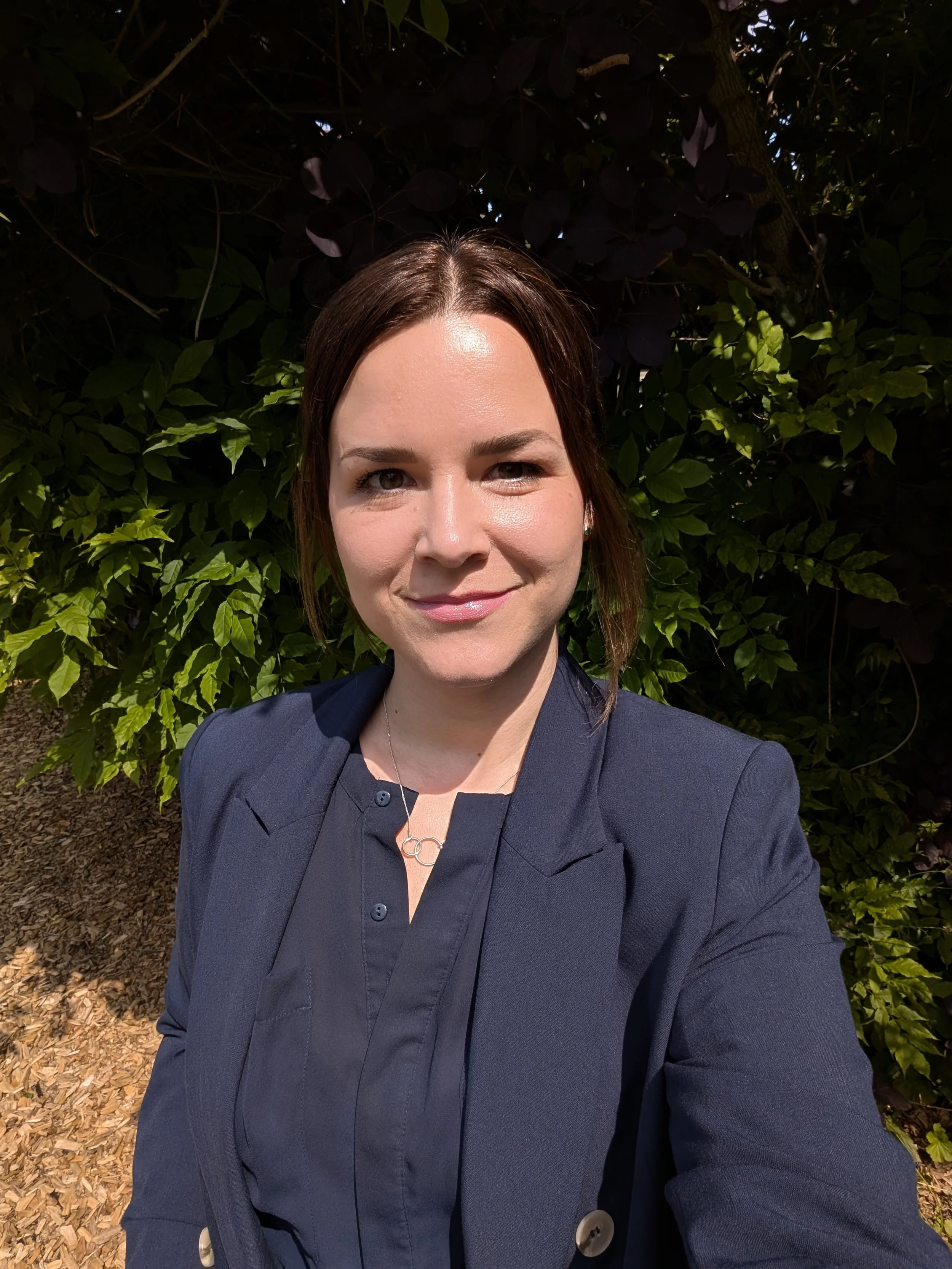 A picture of a woman smiling, dressed smartly.