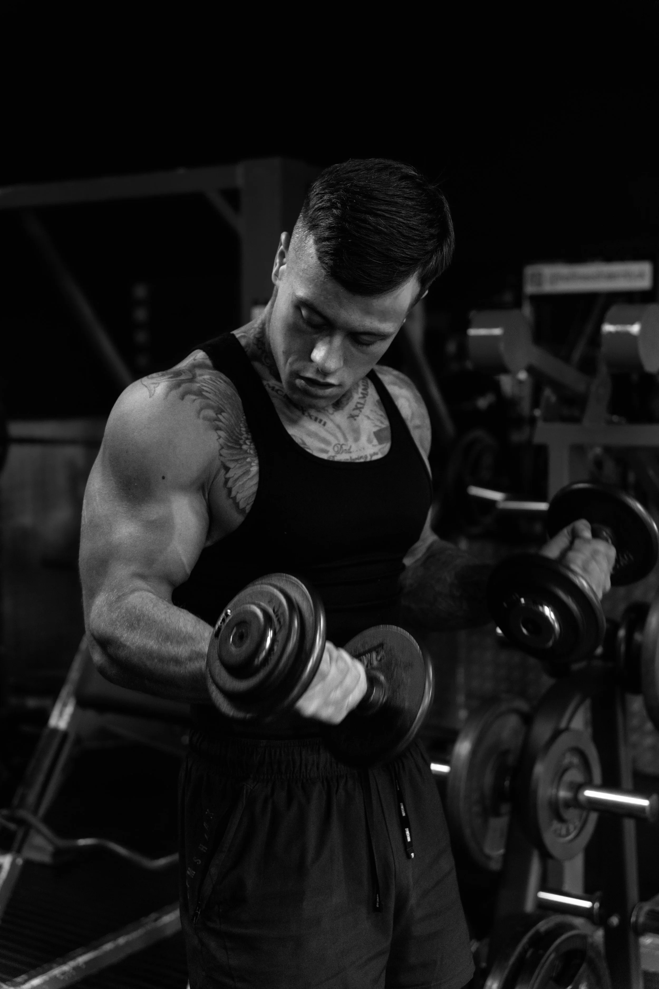 A man lifting dumbbells in a gym.
