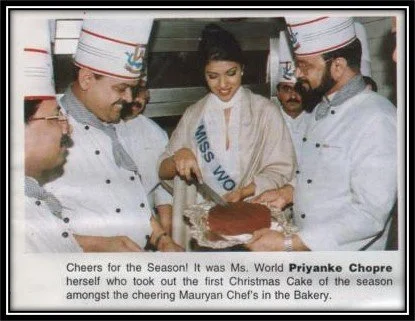 Ms. World Priyanka Chopra is celebrating Christmas with Mauryan Chef and bakery staff, cutting a Christmas cake.