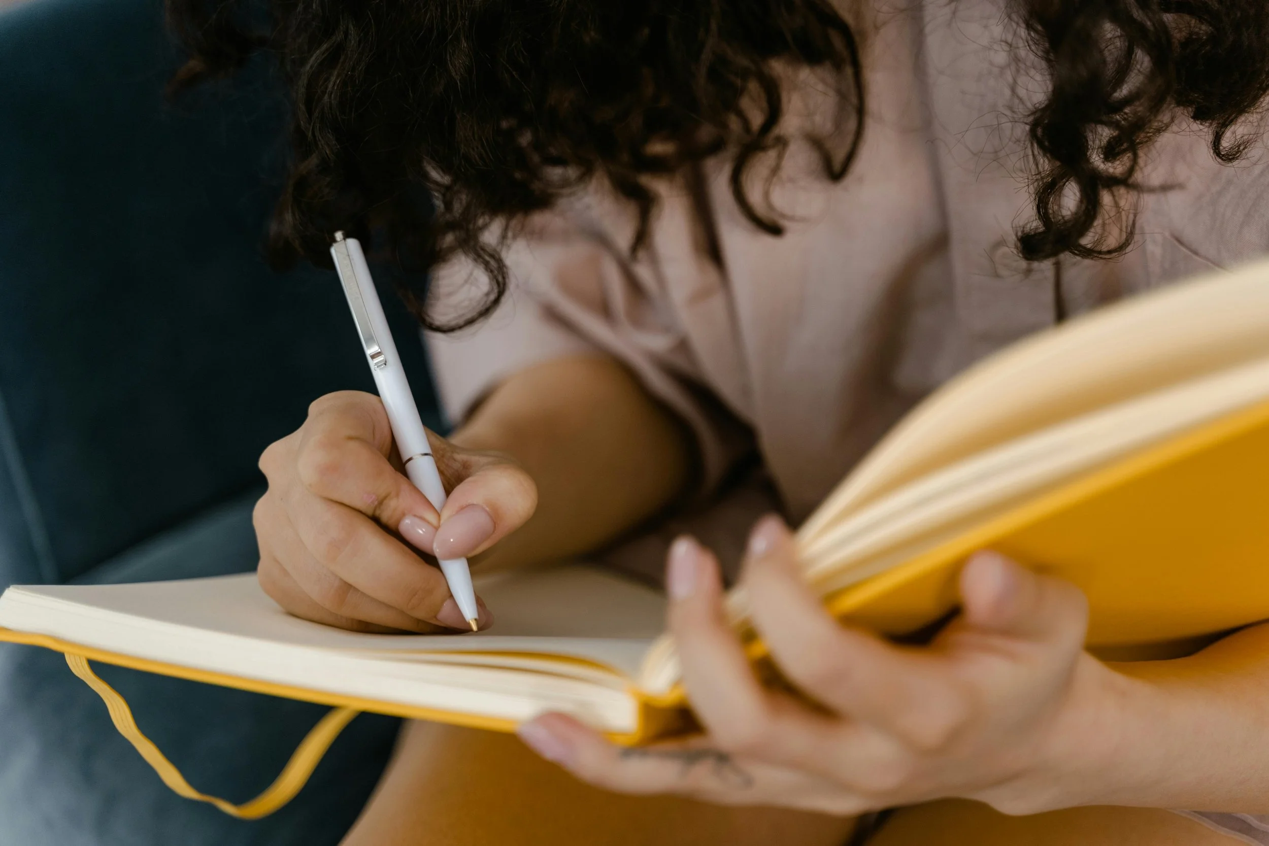 Woman writing in a journal, representing the reflective and healing process of trauma therapy at Inside Out Therapy in Peoria Arizona