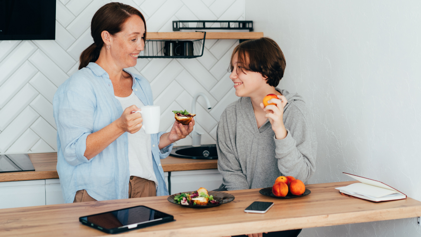 Mother and son standing in the kitchen together eating a snack, representing parent-child attachment therapy at Inside Out Therapy in Peoria Arizona