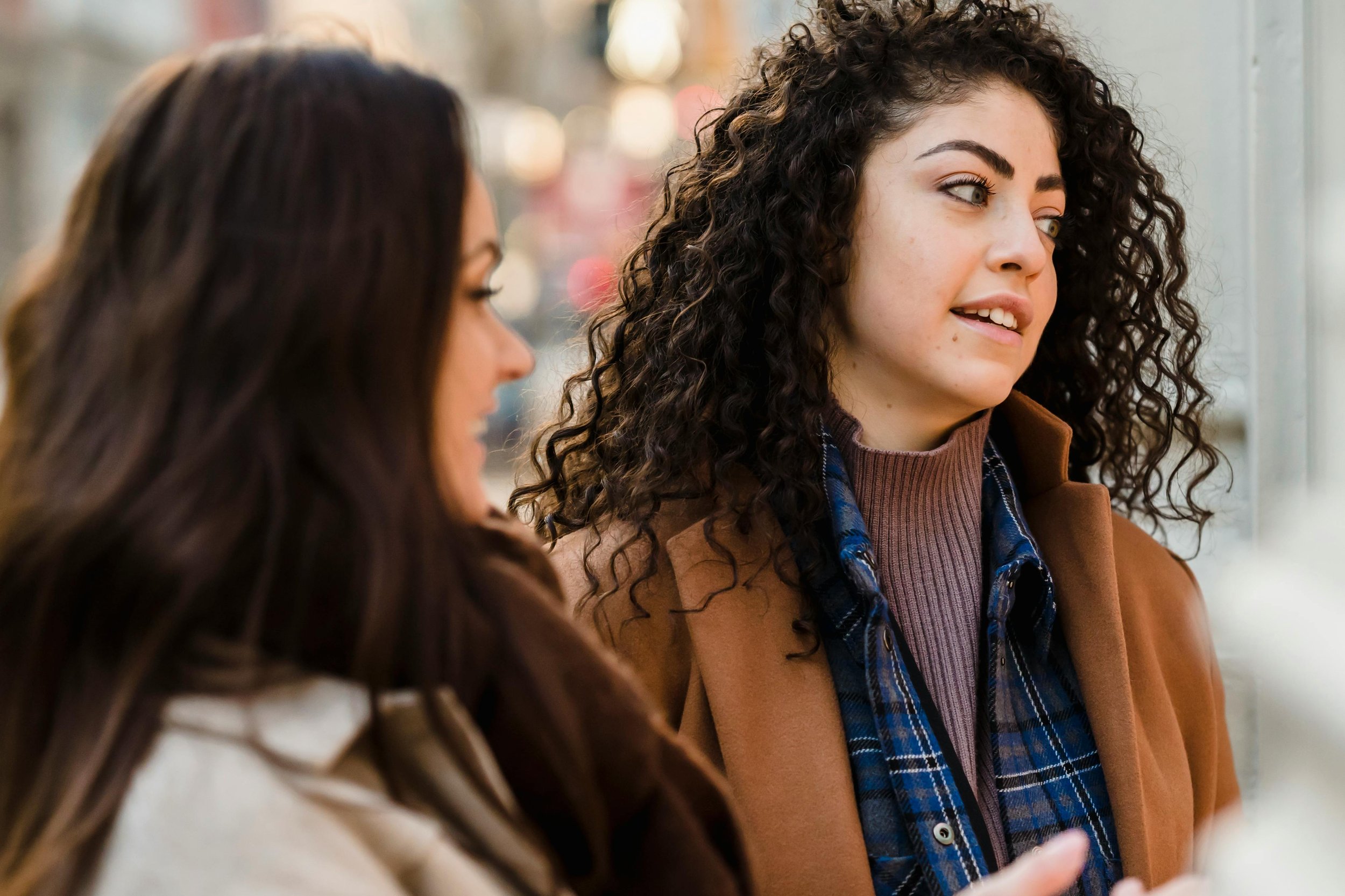 Two teenage girls standing outside talking to each other, representing teen emotional regulation therapy at Inside Out Therapy in Peoria Arizona