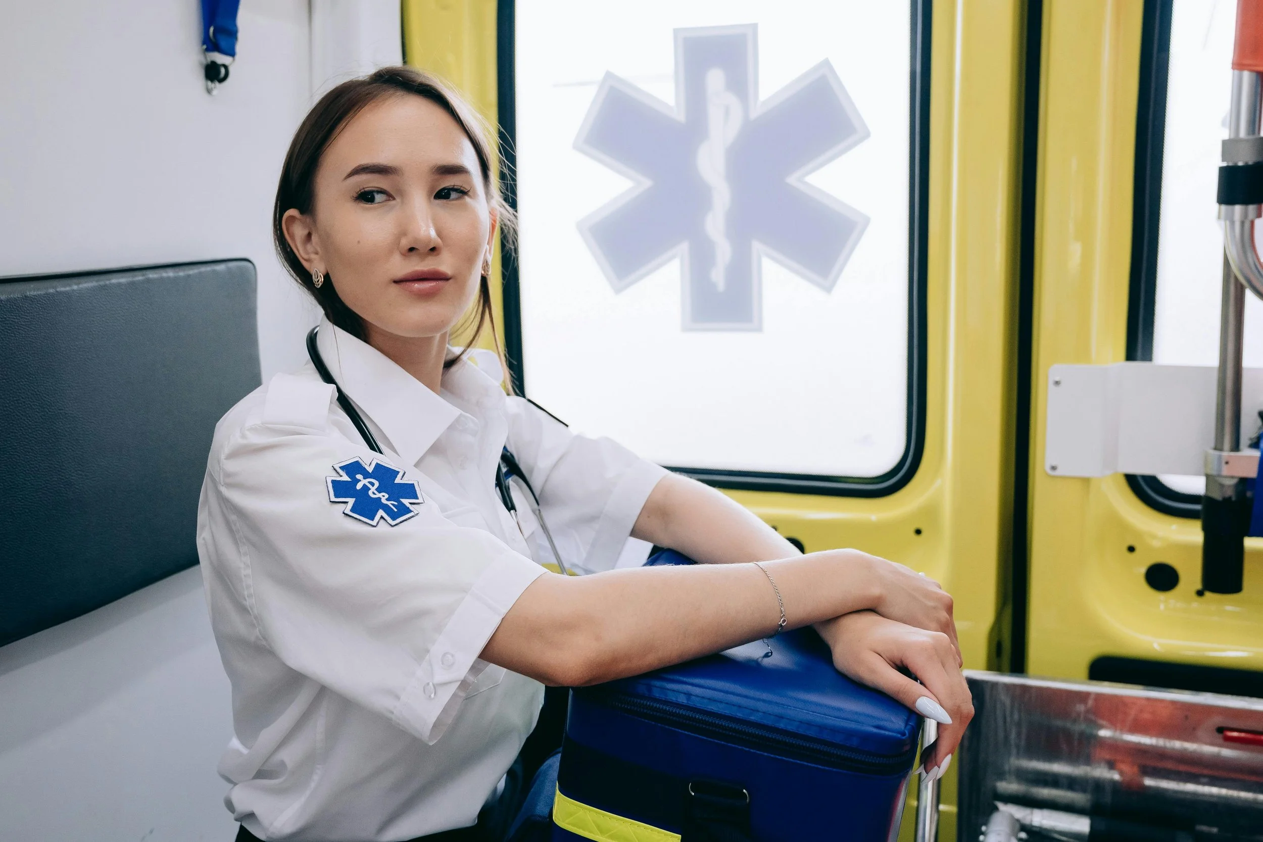 EMS worker in uniform sitting inside an ambulance, representing therapy for first responders and helping professionals at Inside Out Therapy in Peoria Arizona