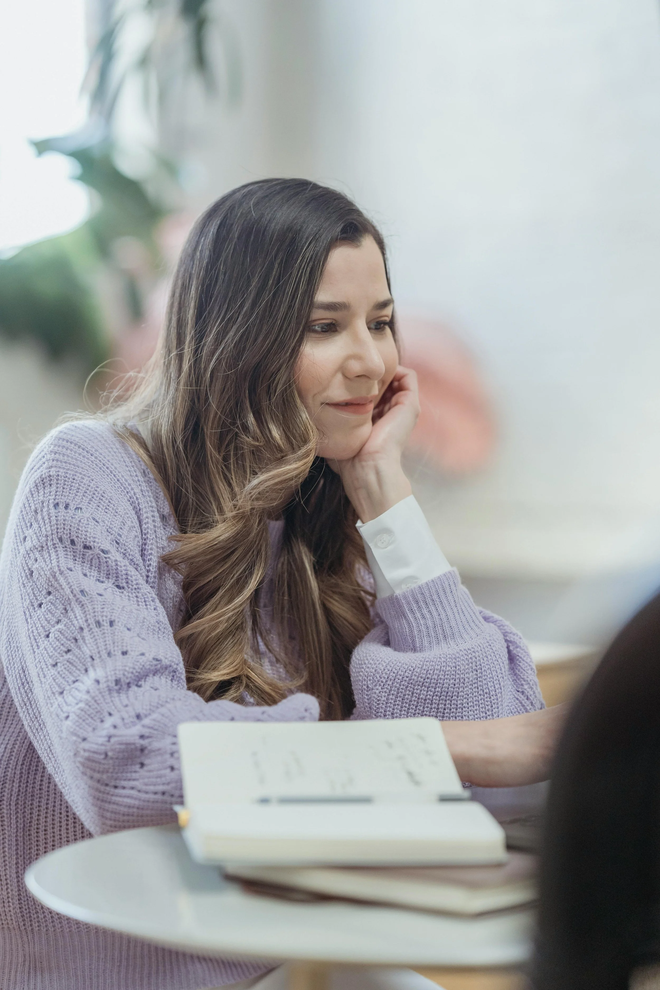 A woman sitting at a desk reading, representing adults seeking a trauma therapist for anxiety in Peoria, AZ
