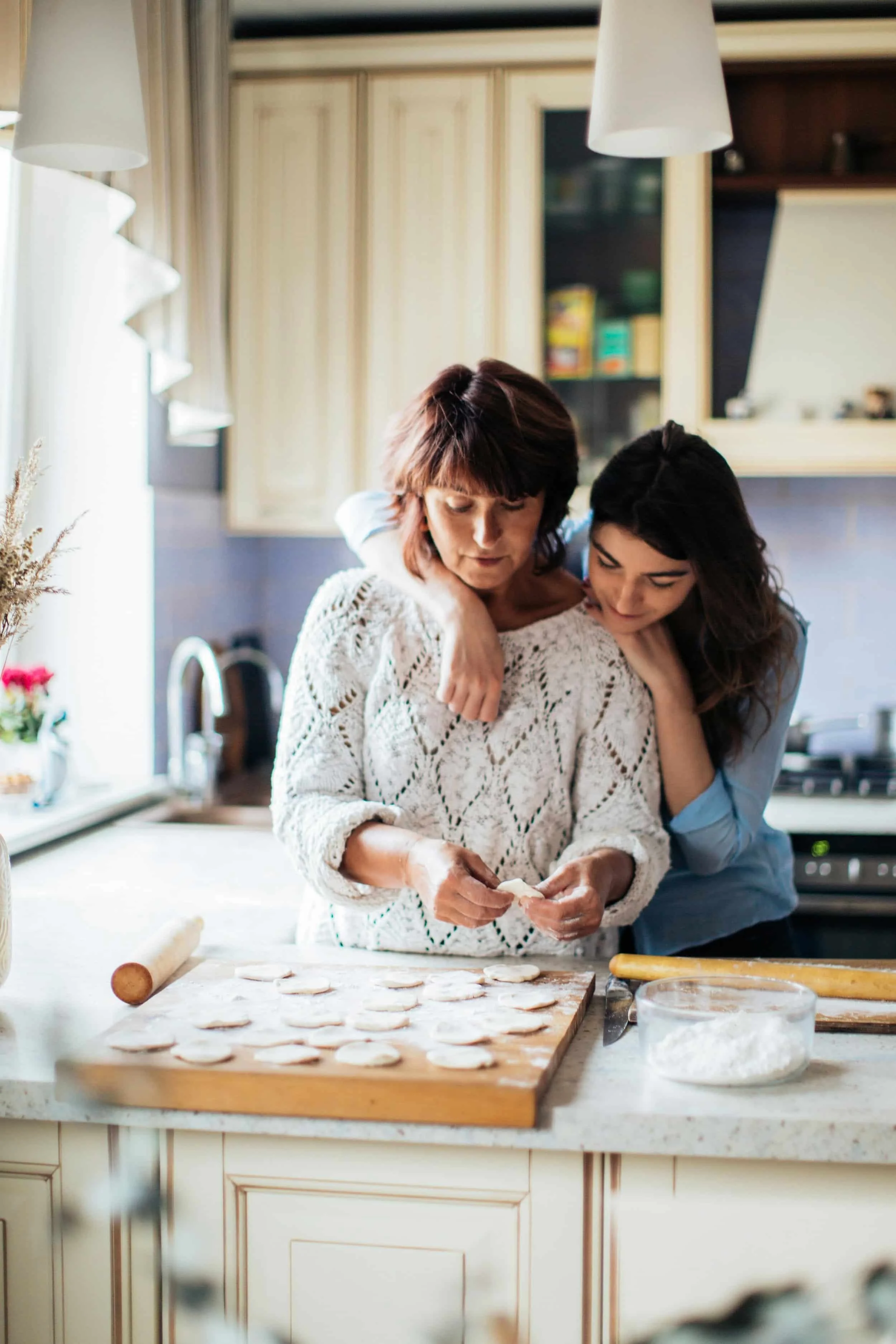 A mother and daughter cooking together in the kitchen, representing attachment-based therapy and family healing in Peoria, AZ