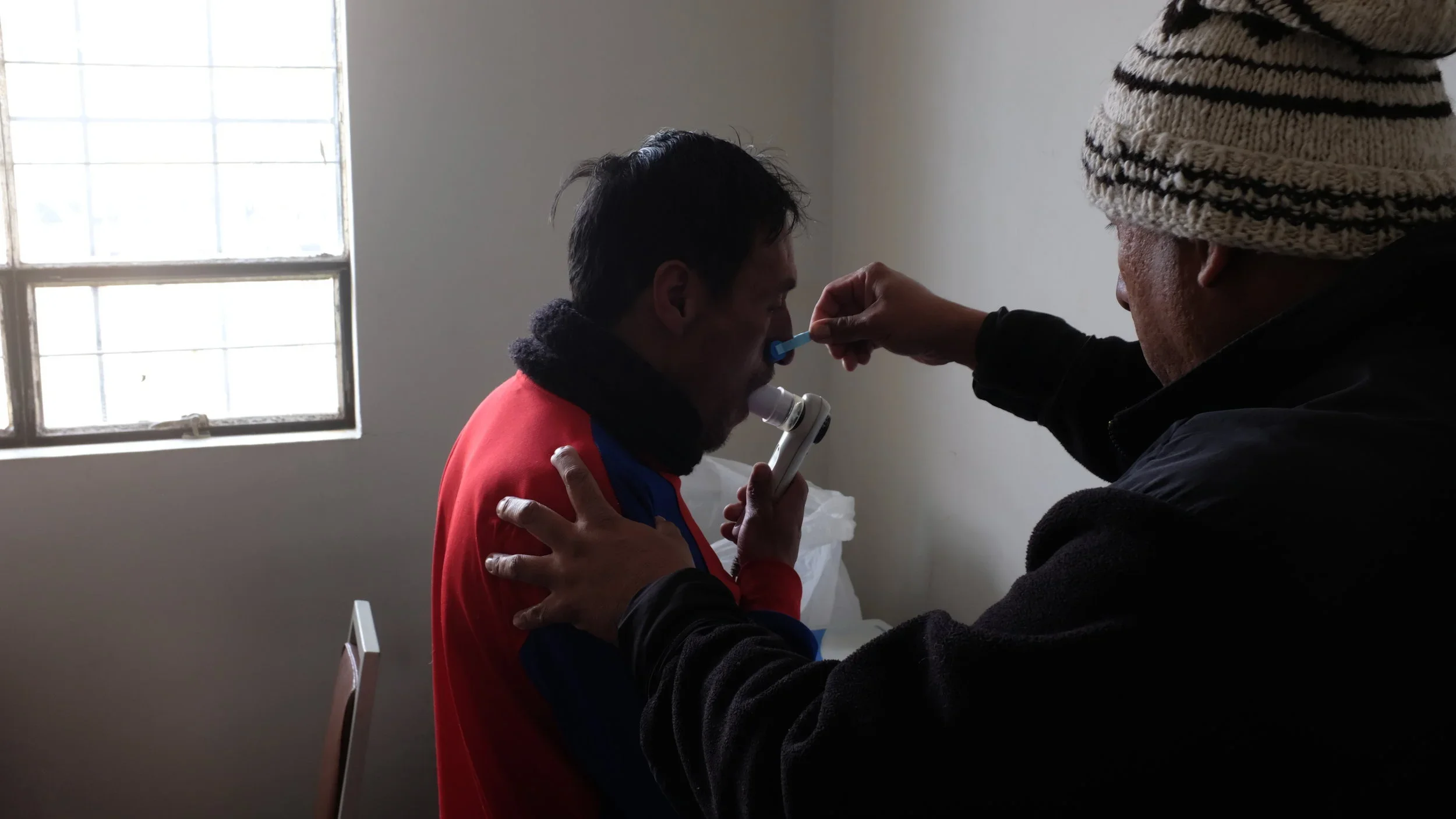 Jose Luis, one of the researchers at the Villafuerte Lab, measures the oxygen capacity of Edwin, a 46-year-old study participant.