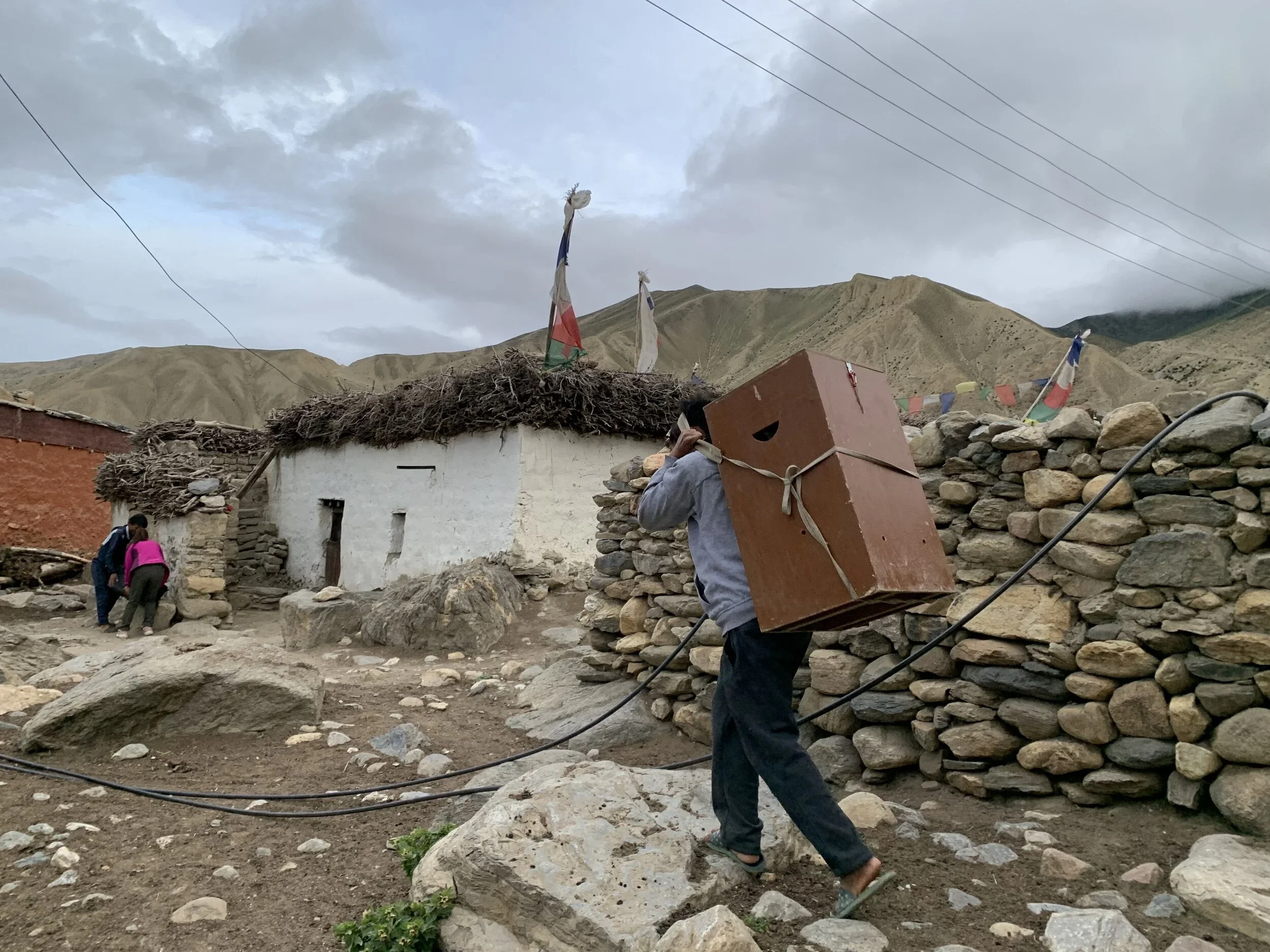 A villager helps carry one of three nitrogen tanks necessary to store samples. 