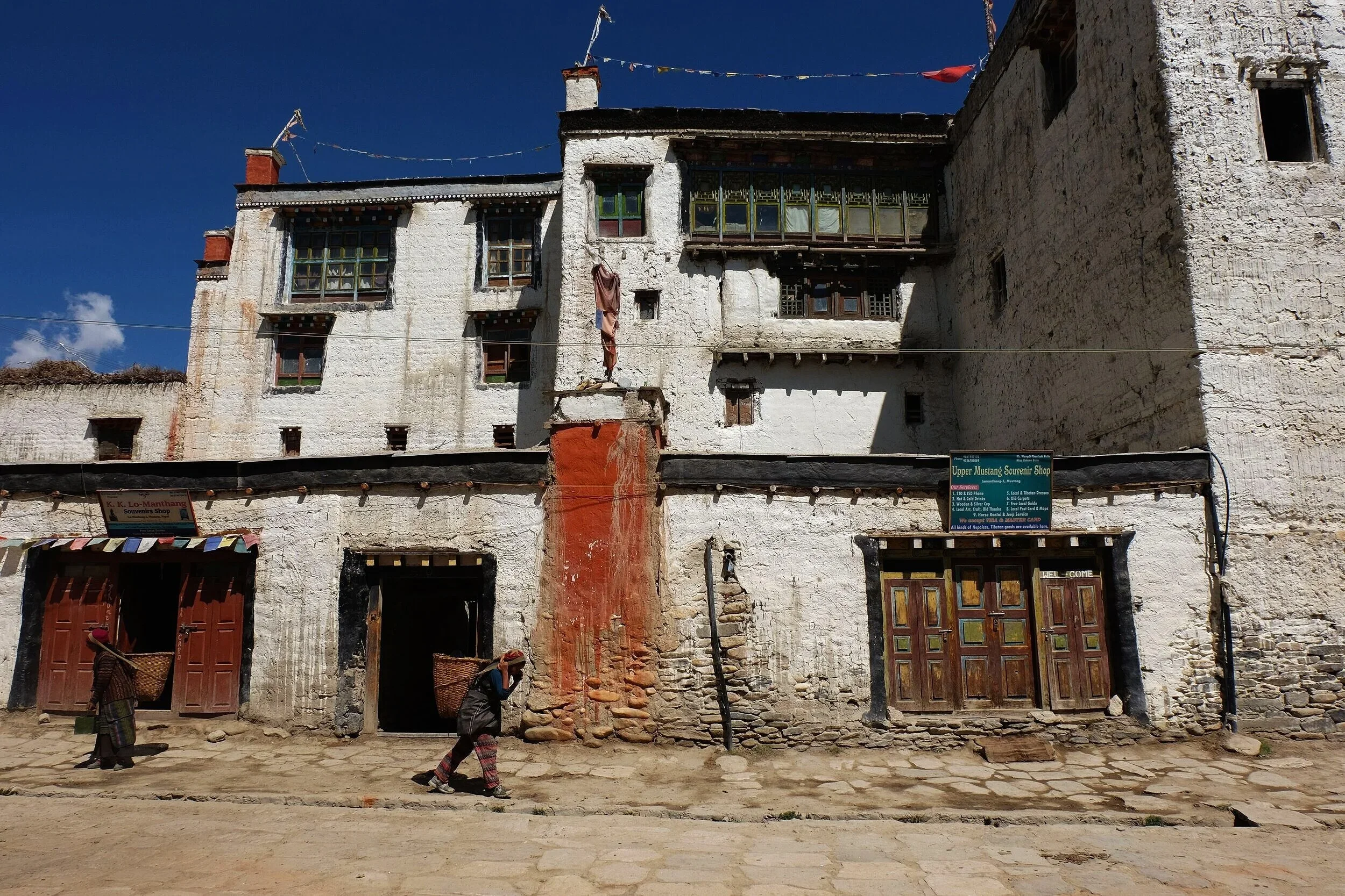 The town of Lo Manthang, where the research team spent multiple weeks collecting data. The sight of women carrying heavy loads is common. 