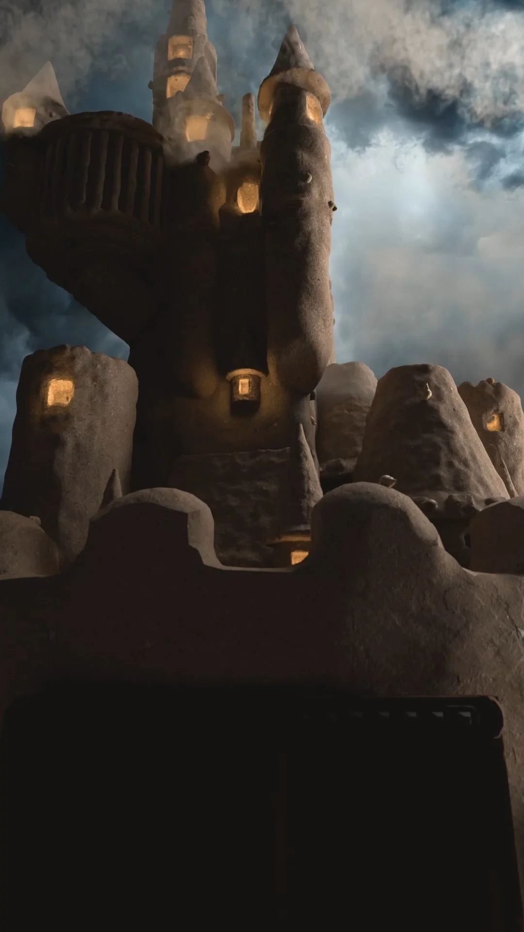 Castello fantasy con torri e mura in pietra, illuminato da luci calde in un cielo nuvoloso.