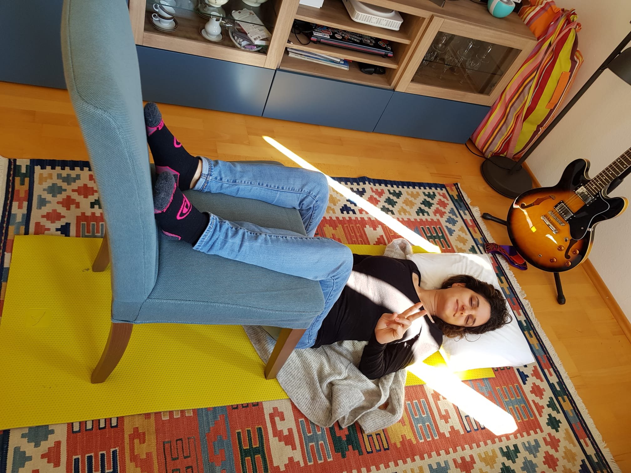 Woman laying on floor with legs on a chair