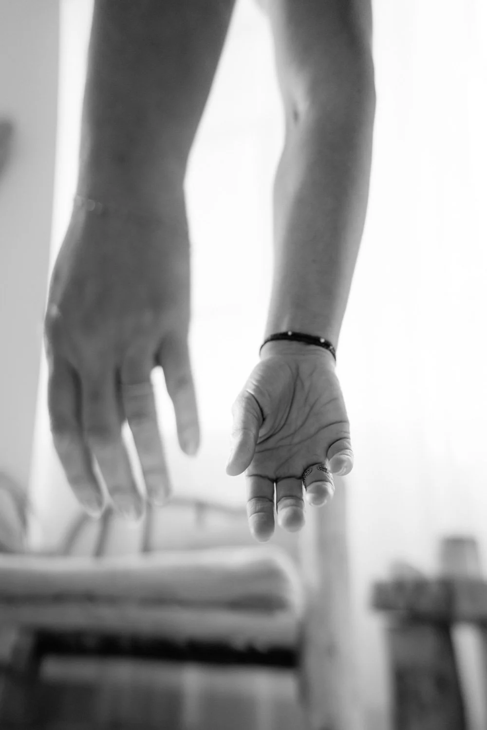 Close up of draping hands in yoga forward fold, Uttanasana