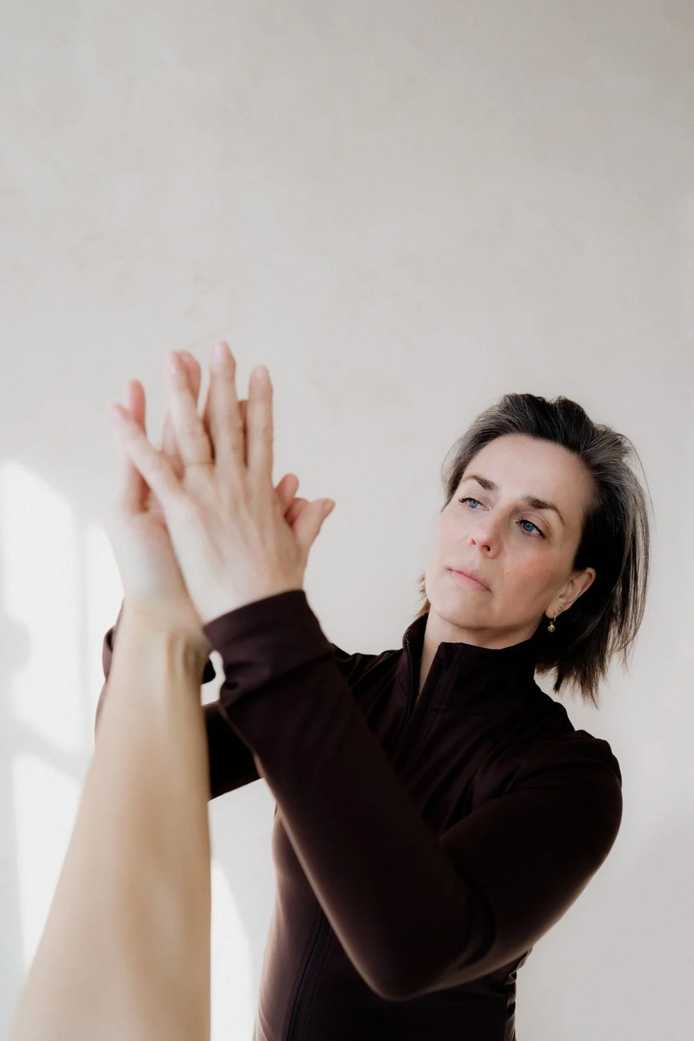 Close up yoga teacher Marlijn assisting student hand