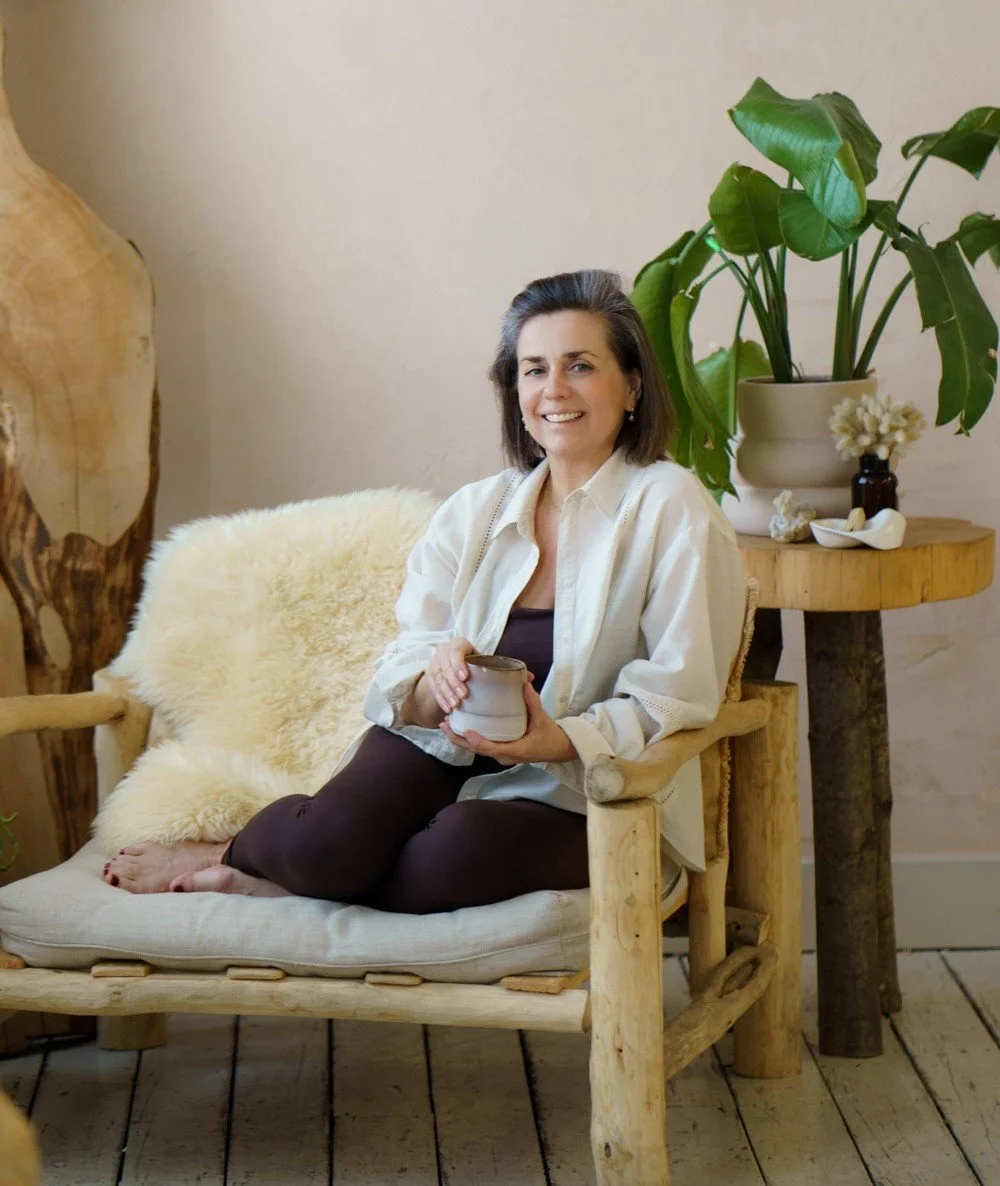 Yoga teacher Marlijn holding a mug of tea, smiling and looking at the camera