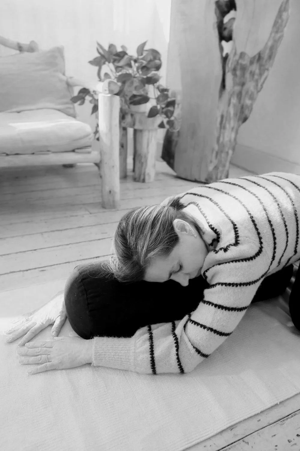Yoga teacher Marlijn resting in child's pose over a bolster