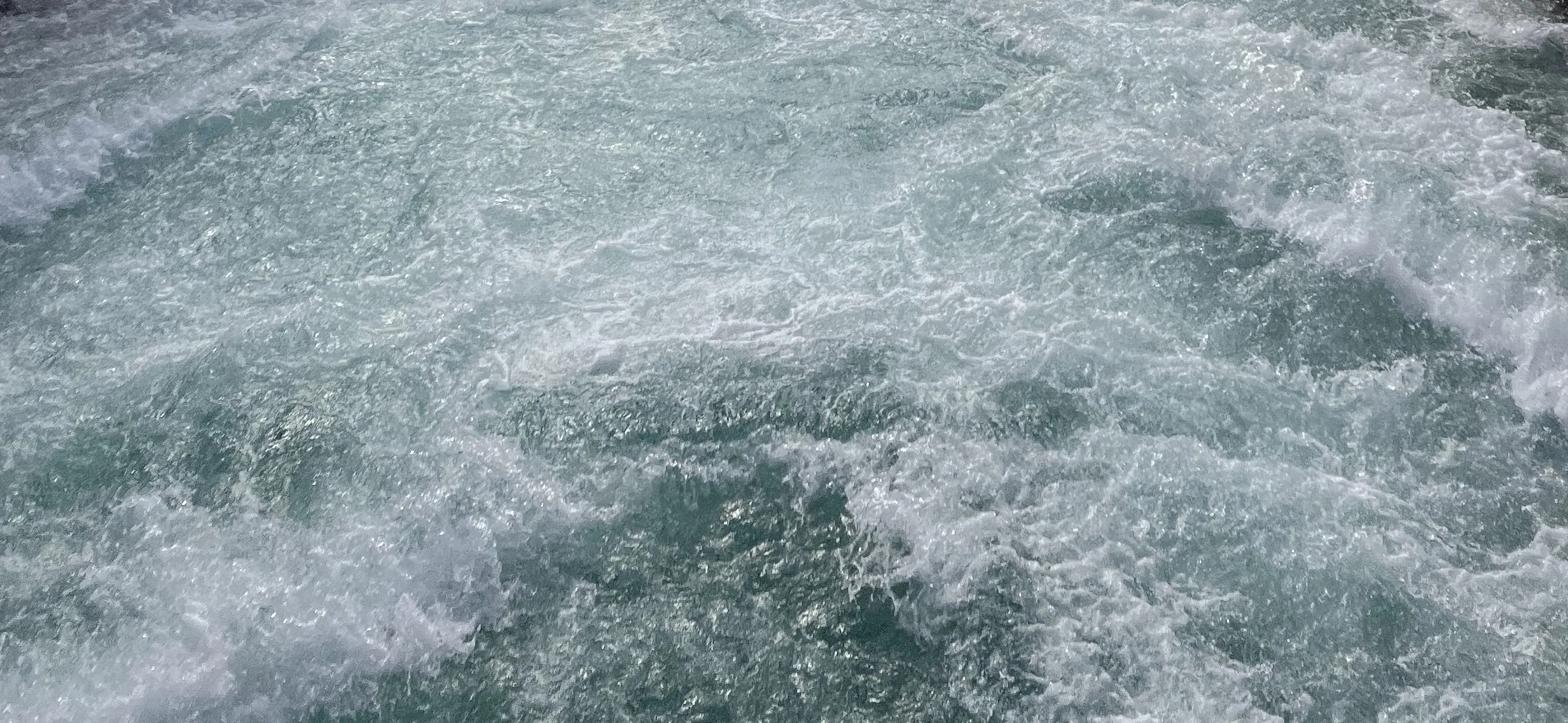 Choppy ocean water with whitecaps and foam.