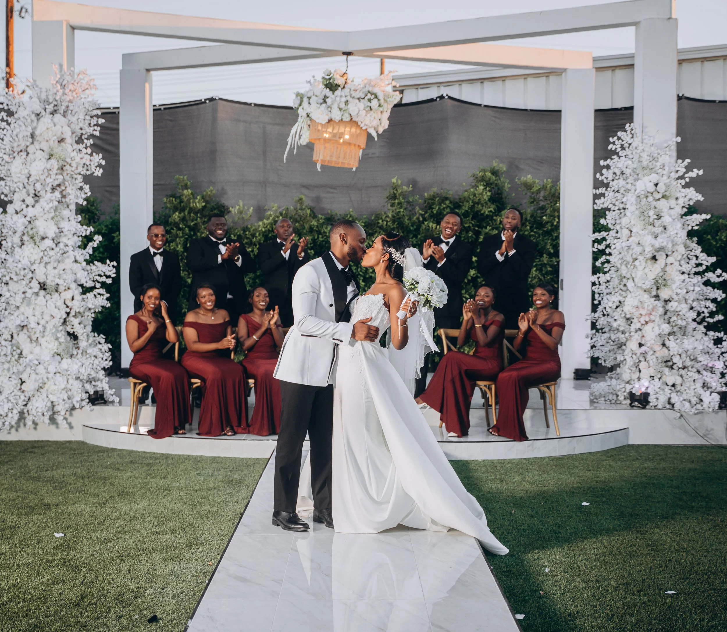 Laurie’s customers, Mariana and Carmen holding hands on a green lawn on their wedding day.