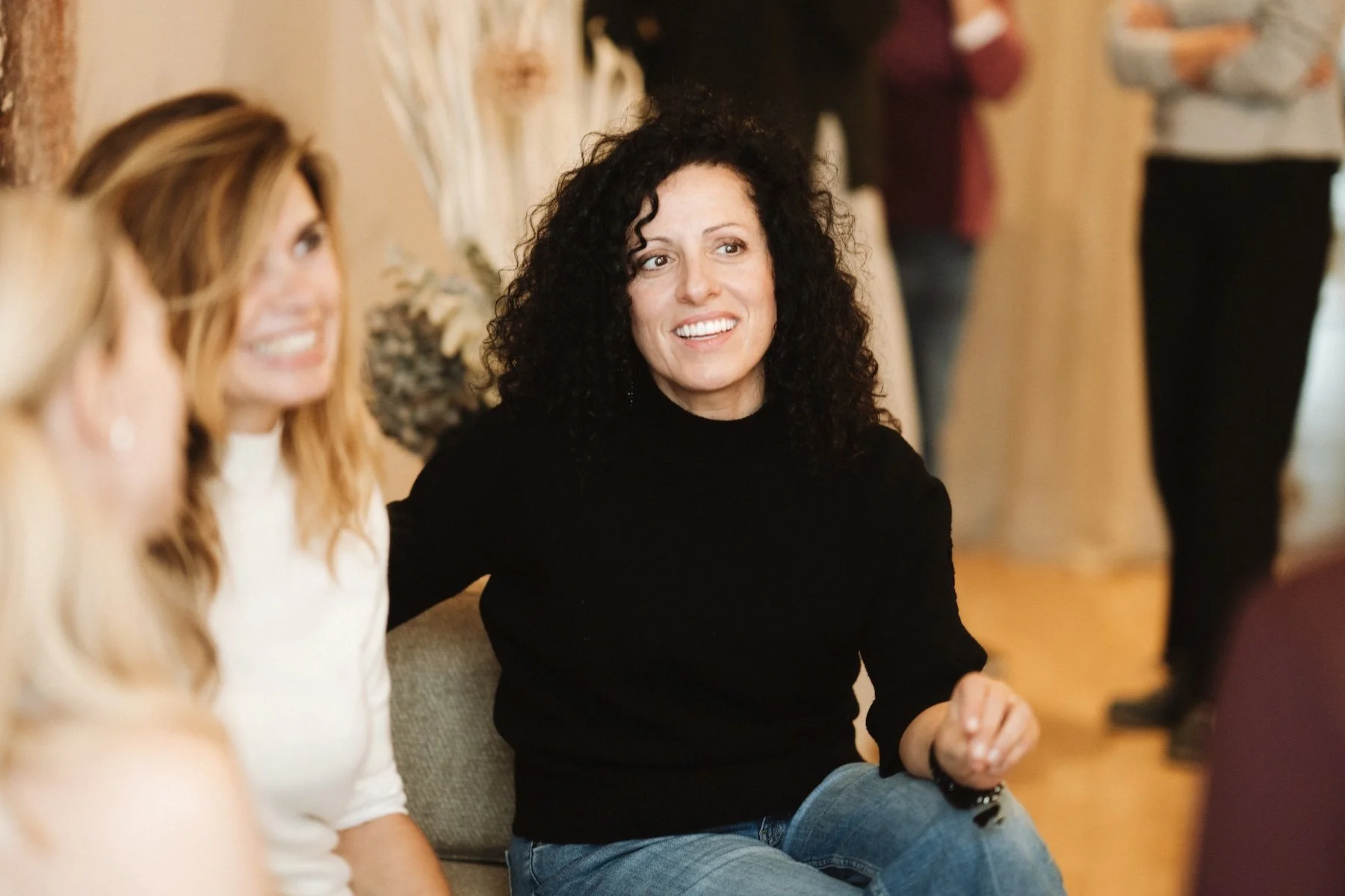 Menschen sitzen und sprechen bei einem sozialen Treffen in einem gemütlichen Raum.