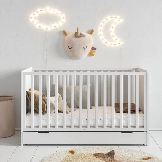 Nursery room with a white crib, plush pillows, wall decor including a unicorn head and LED cloud and moon lights.