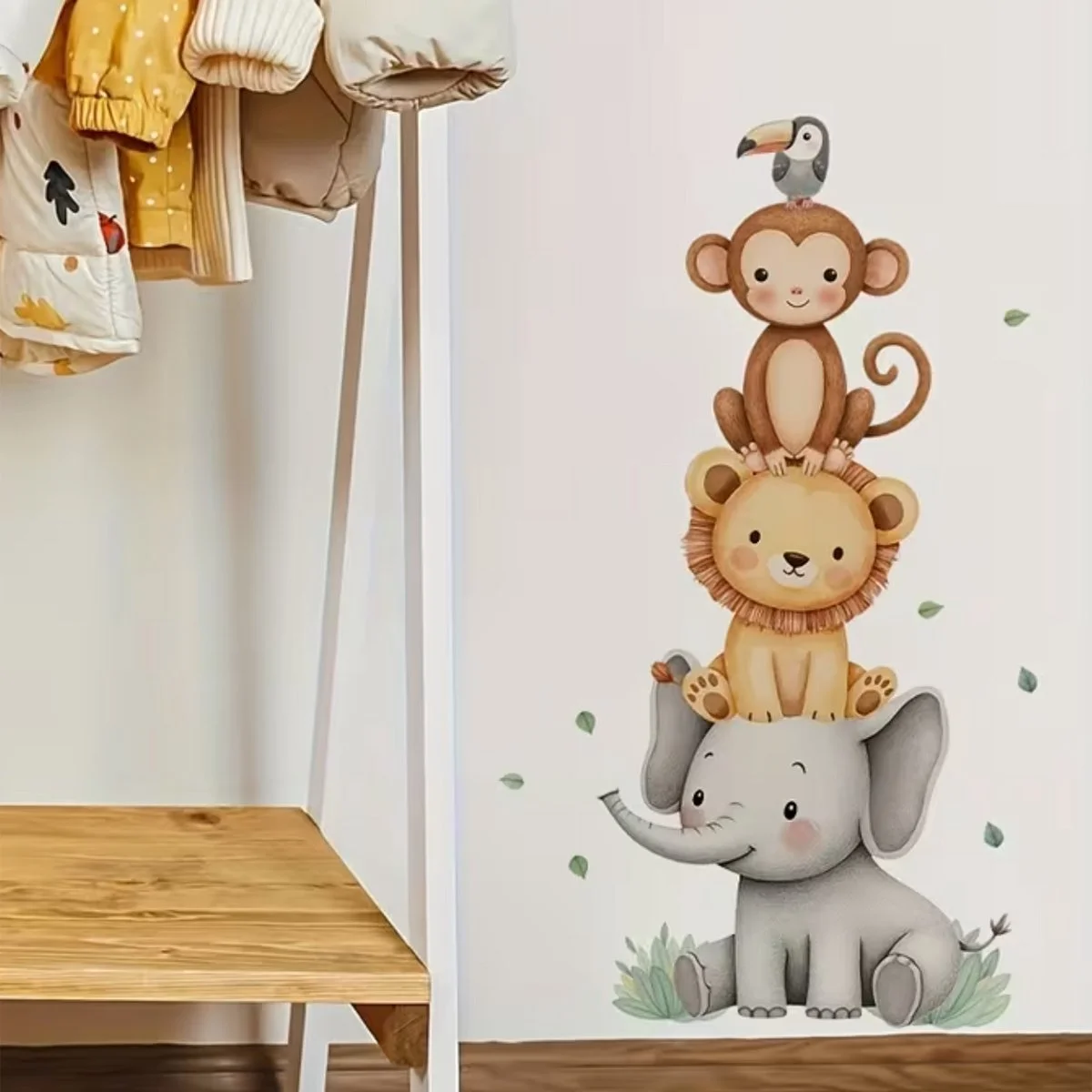 Decorative wall with cartoon-style animals stacked: an elephant, lion, monkey, and toucan, with small green leaves around.