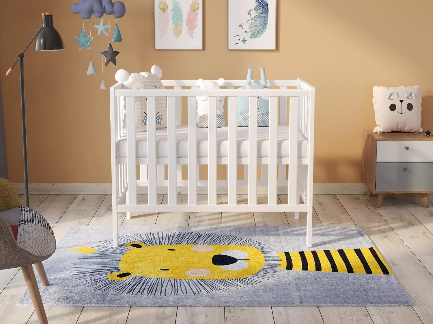 A nursery room with a white crib, decorative pillows with animal faces, a colorful rug with a lion design, a wooden dresser with a bear-shaped pillow, framed wall art with feathers and leaves, a black floor lamp, and a hanging cloud and star mobile.