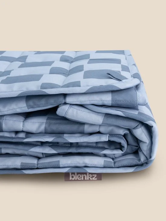 Folded blue and white patterned blanket with a brand tag labeled 'blenkz' at the bottom.