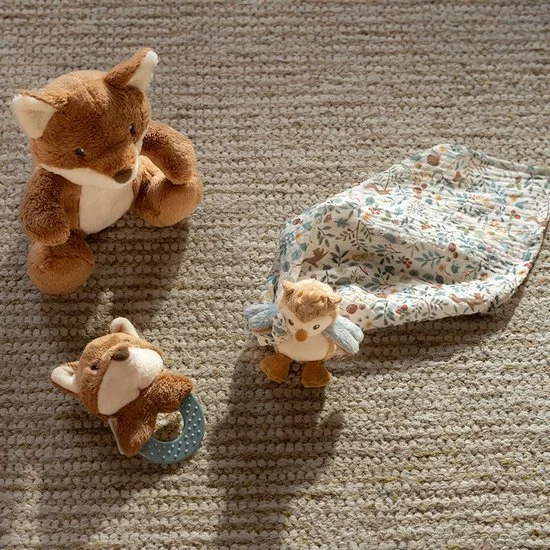 Three plush animal toys and a fabric pouch with a floral pattern on a textured beige carpet.