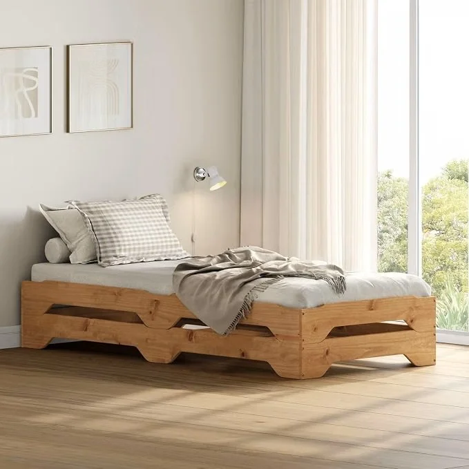 A minimalist bedroom with a wooden bed frame, a checkered pillow, a blanket, a wall-mounted reading lamp, and large windows with sheer curtains allowing natural light to enter.