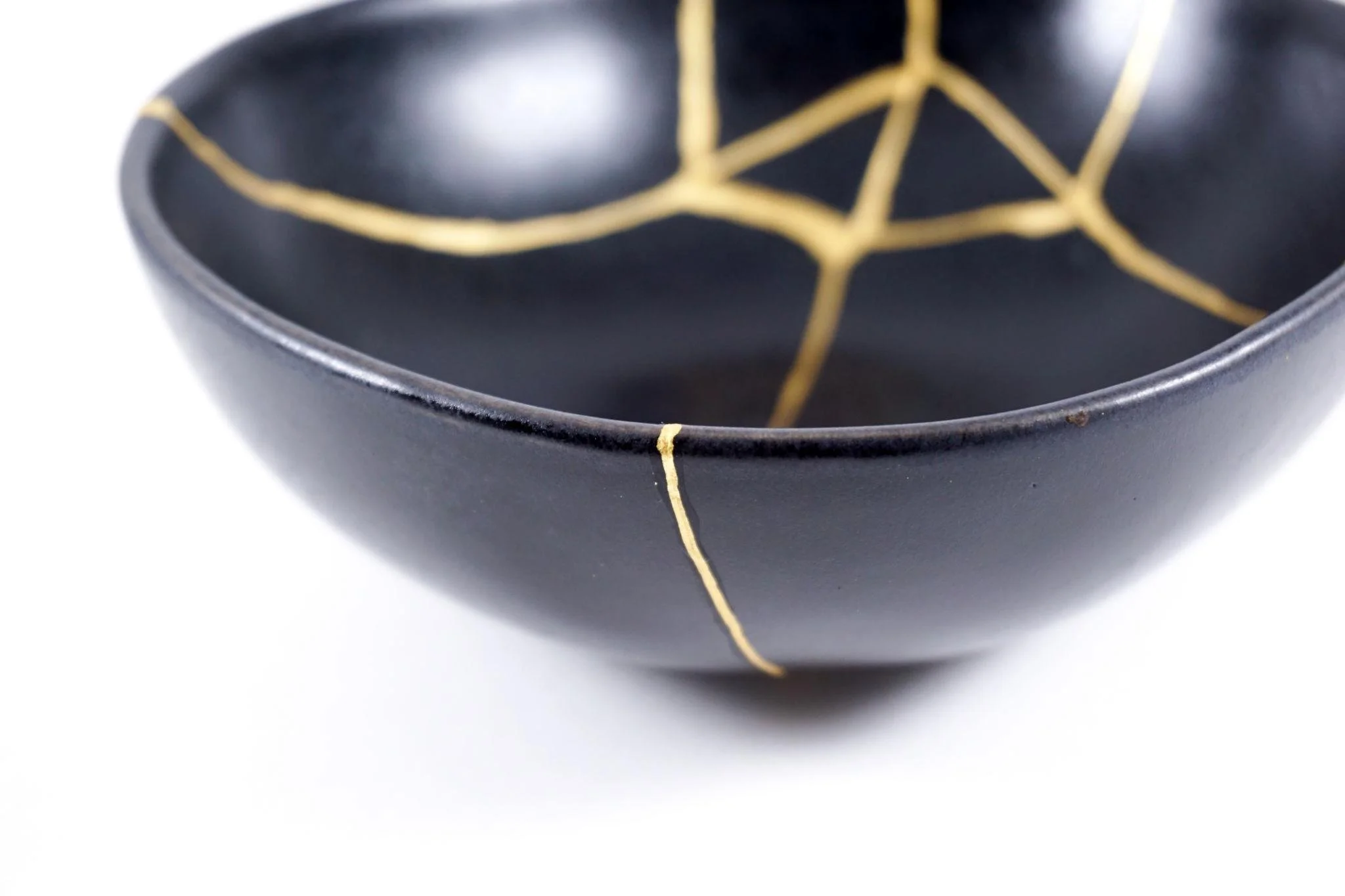 Close-up of a black ceramic bowl with gold geometric designs.