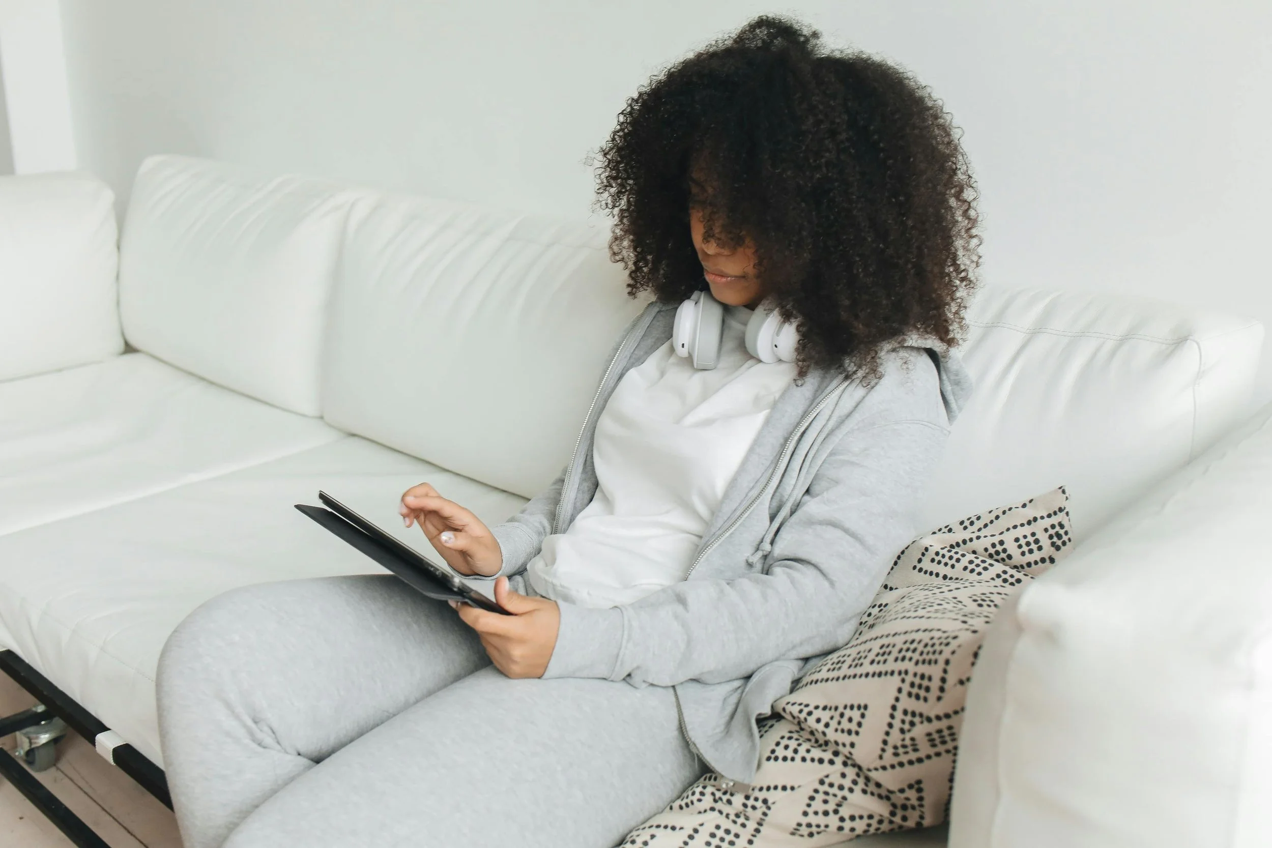 Photo by Polina Tankilevitch: https://www.pexels.com/photo/woman-with-afro-hair-sitting-on-sofa-while-using-a-tablet-7382352/