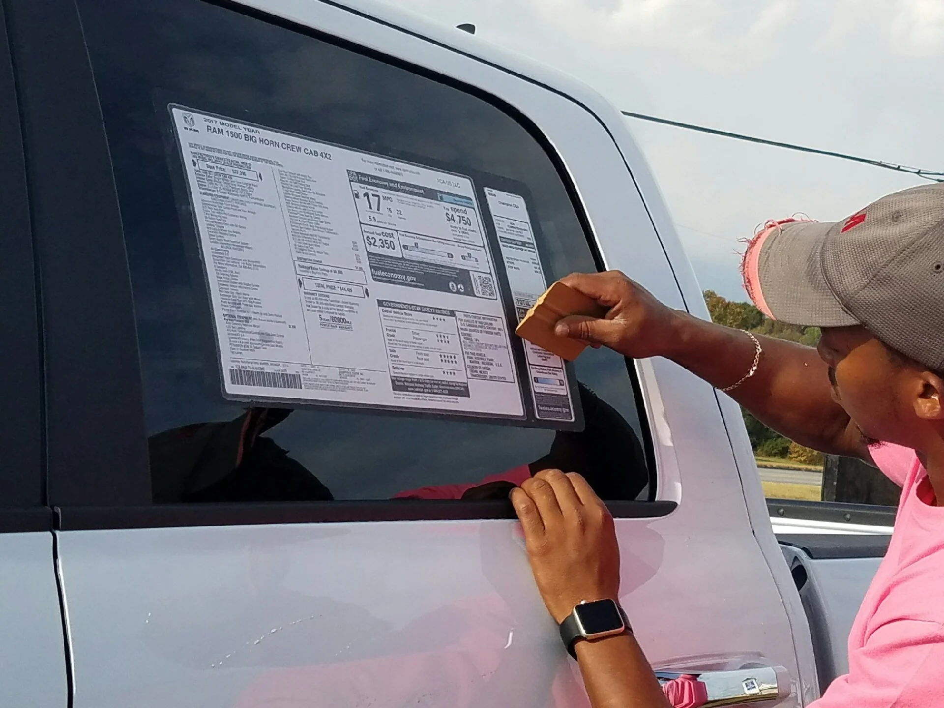 Dealership custom labels and adendums being printed and applied to vehicles by On the Spot Dealer Services.