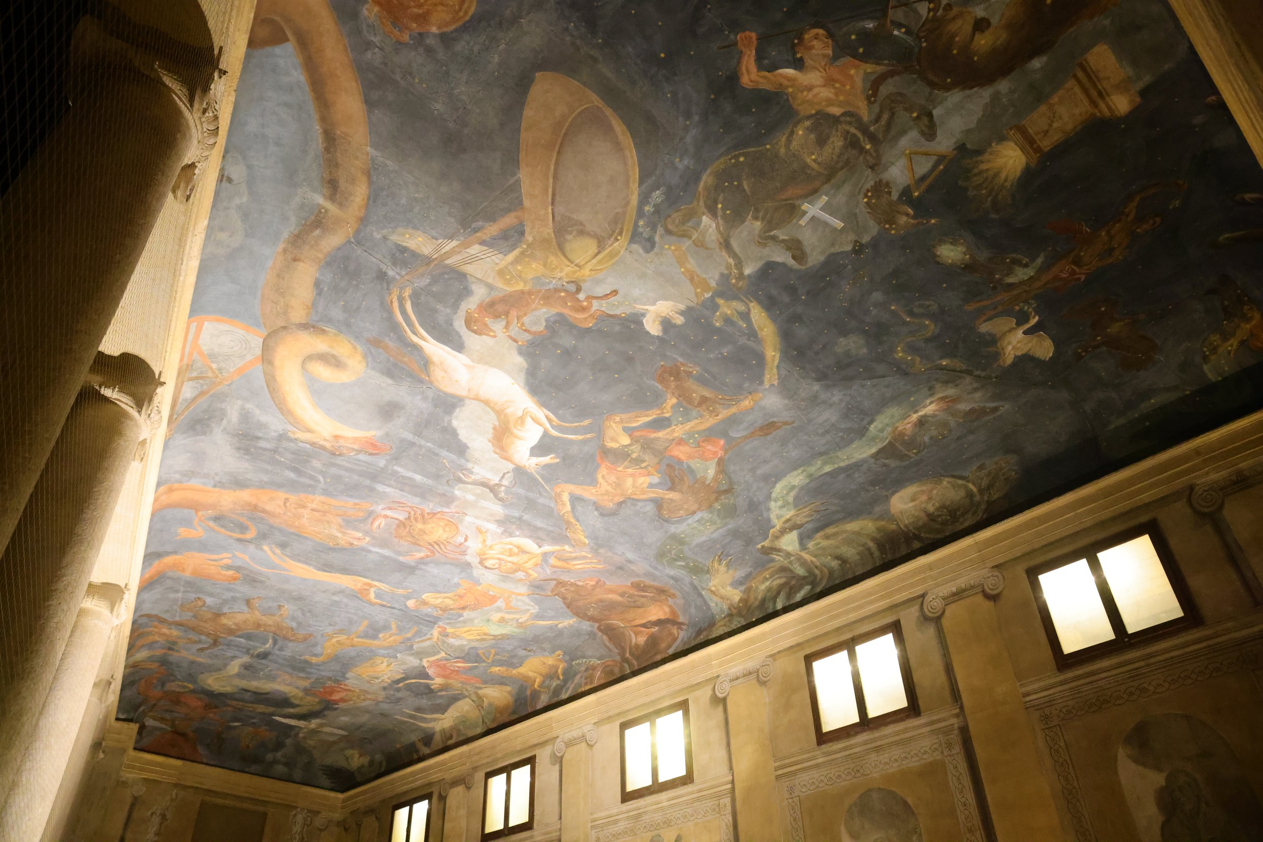Fresco ceiling artwork depicting mythological creatures, figures, and celestial scenes, with intricate framing and lighting.