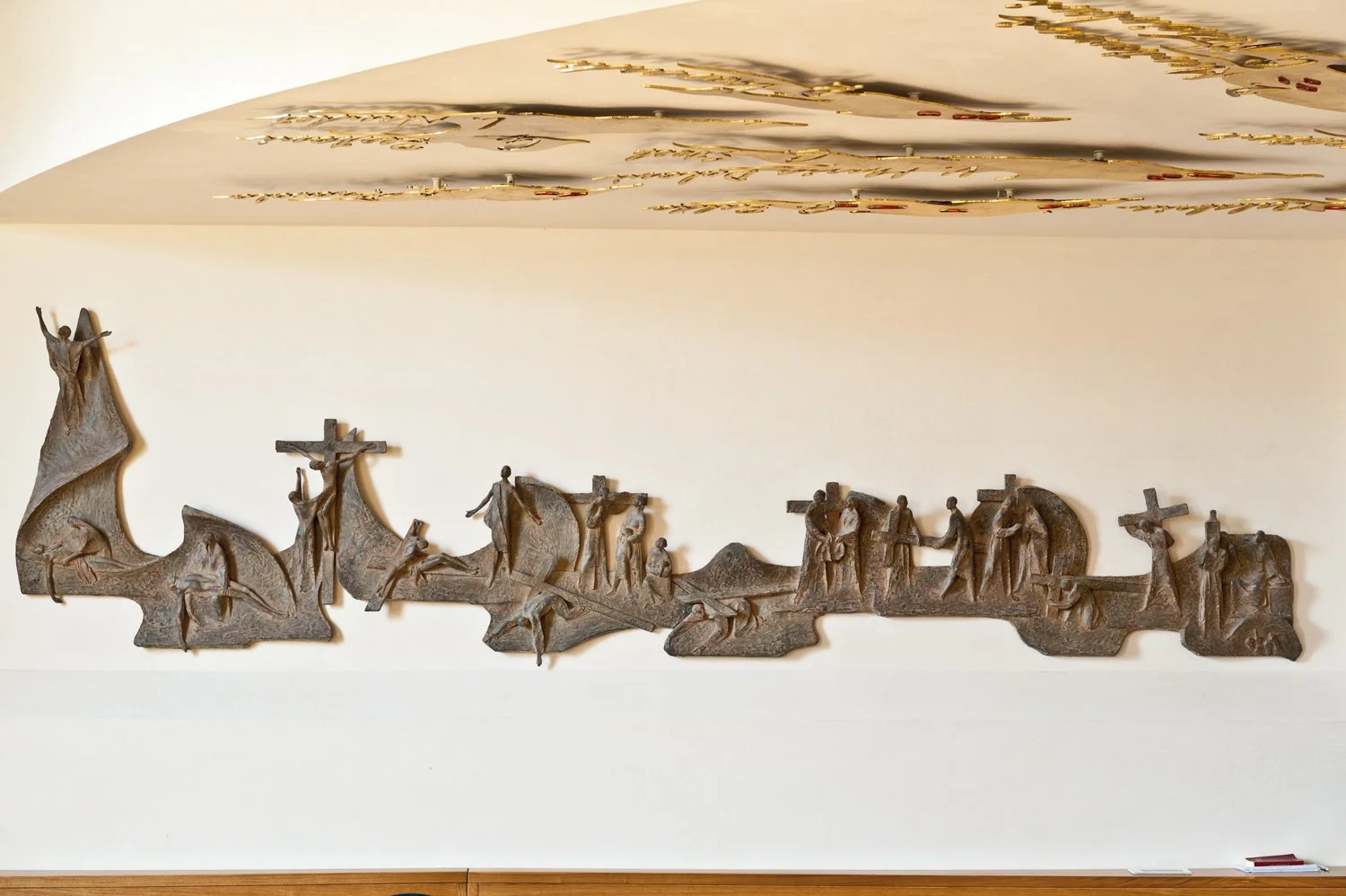 A wooden sculpture depicting the Stations of the Cross with multiple figures representing Jesus' crucifixion and related events.