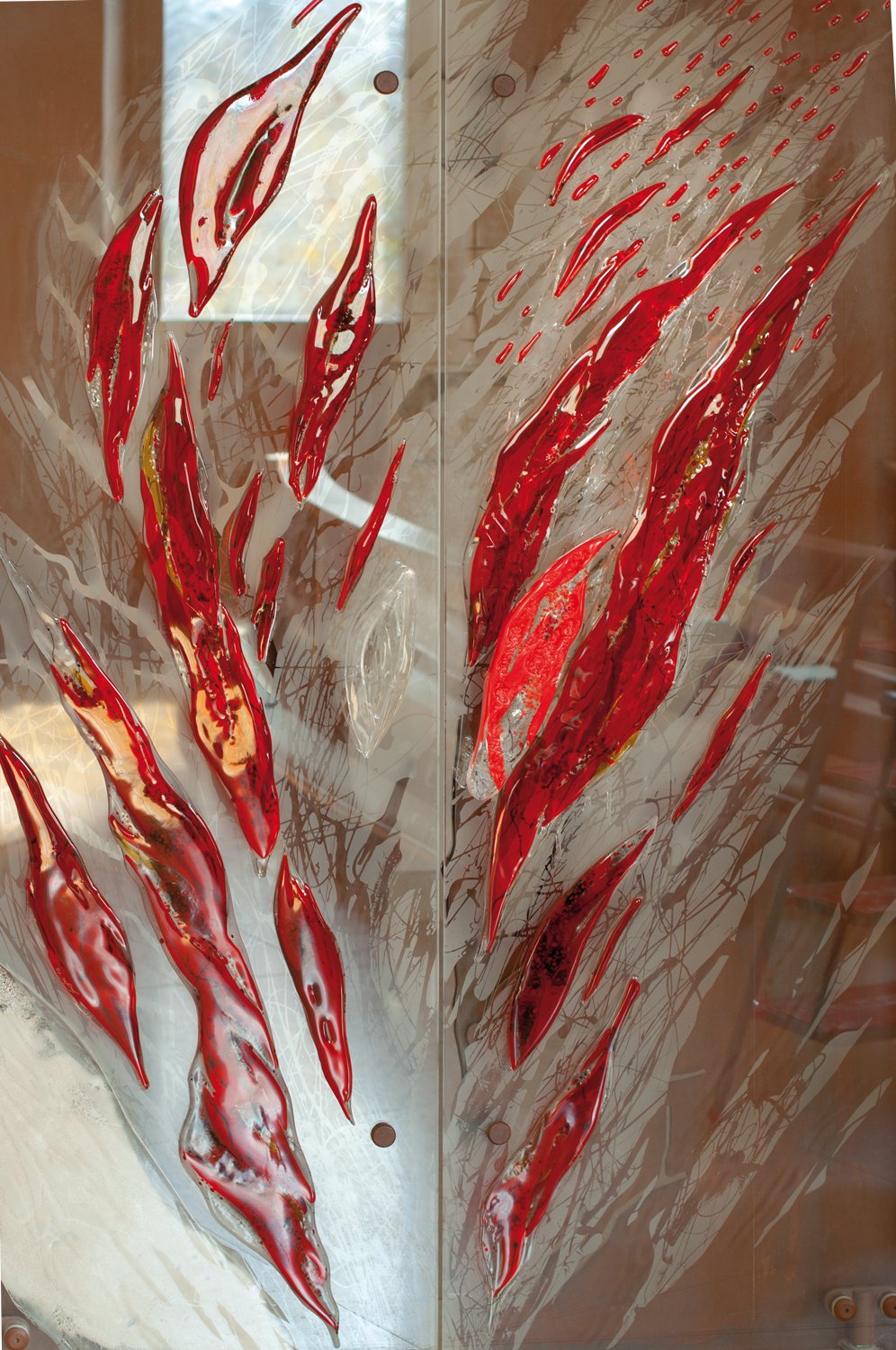 Abstract artwork featuring elongated, curved red and gold glass shapes on a textured background with brown and beige tones.