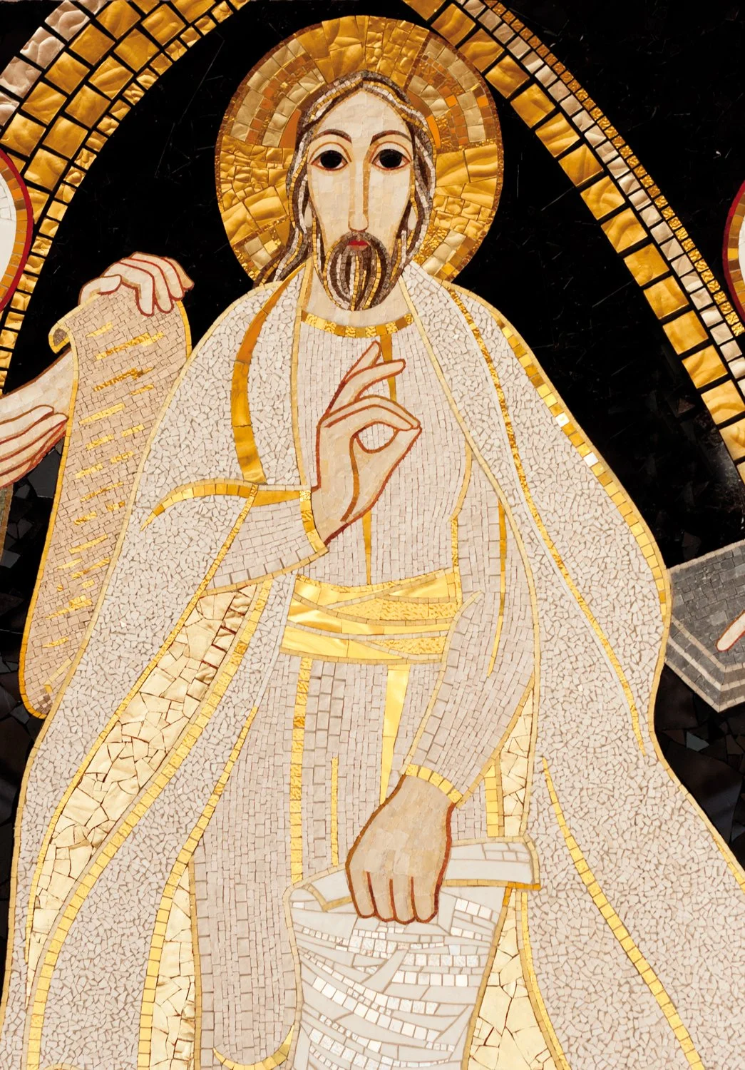 Mosaic depiction of Jesus Christ with a halo, making a gesture with his right hand and holding a scroll in his left hand.