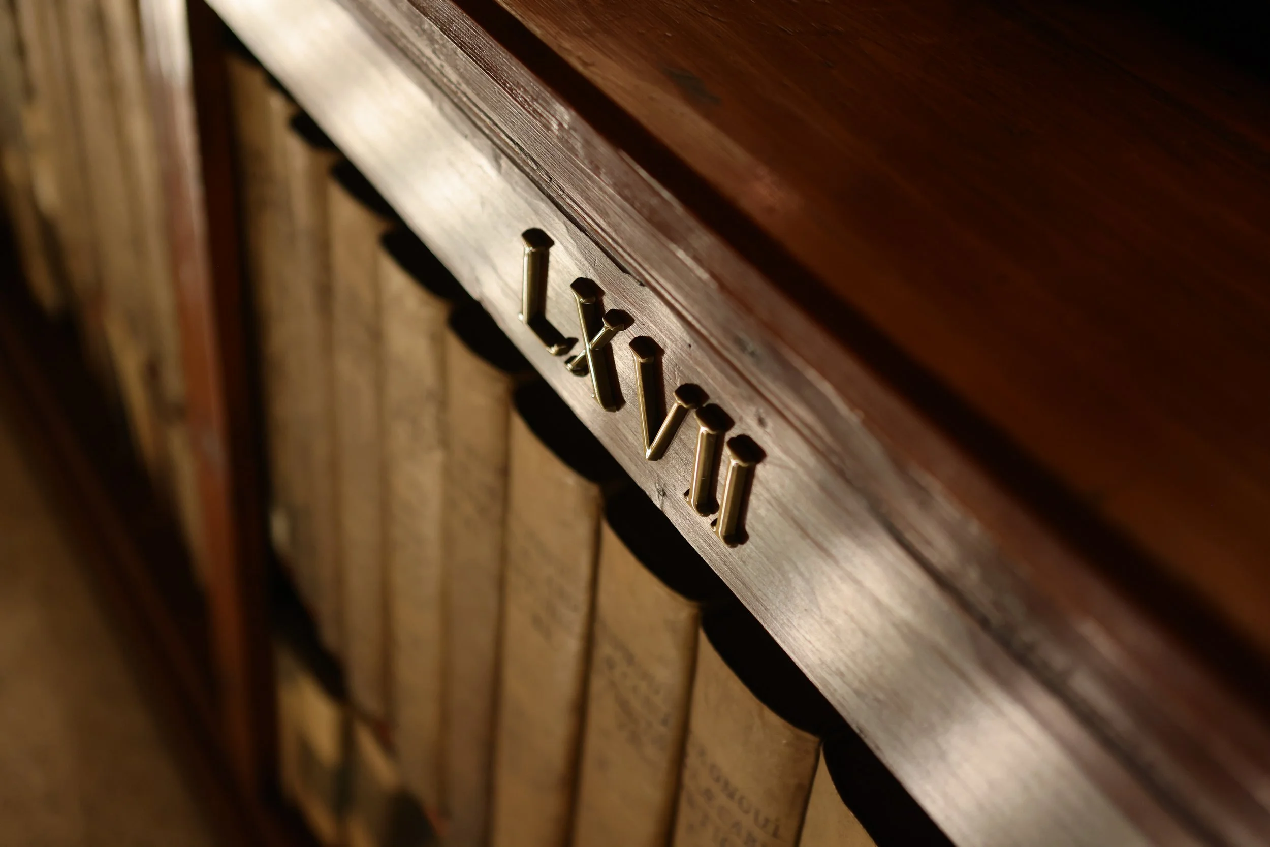 Close-up of a wooden drawer with gold metal handles.